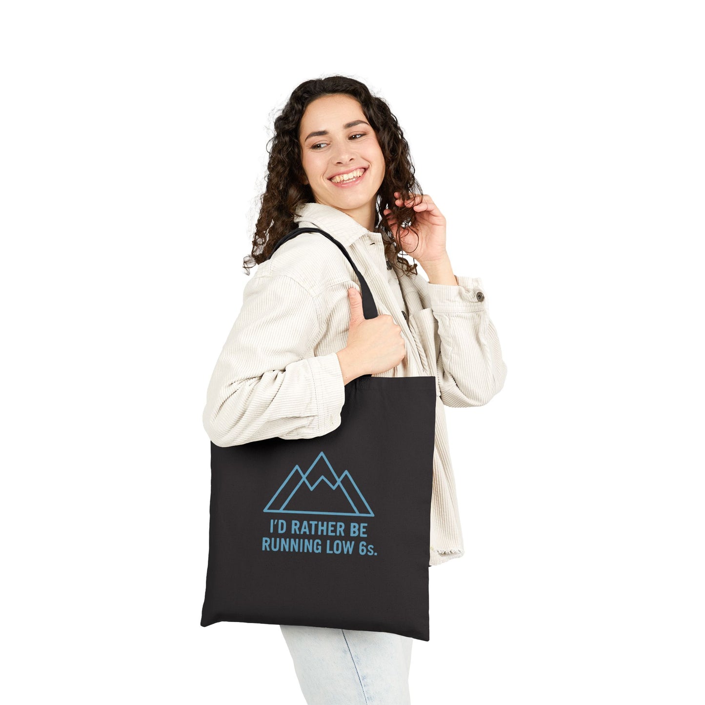 Woman holding a black tote bag with text 'I'd rather be running low 6s' and a mountain graphic on a white background
