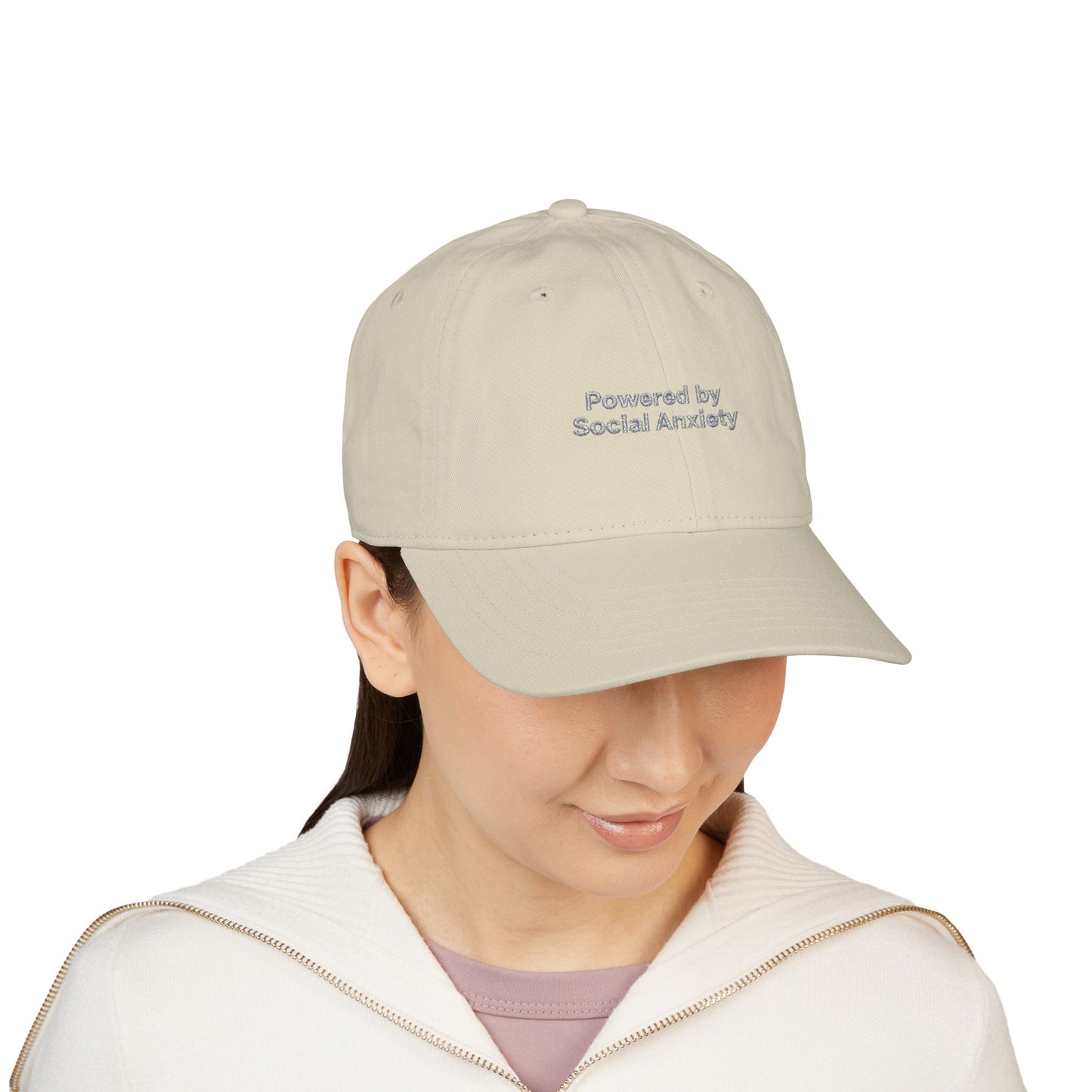 Person wearing a beige cap with 'Powered by Social Anxiety' text on a white background