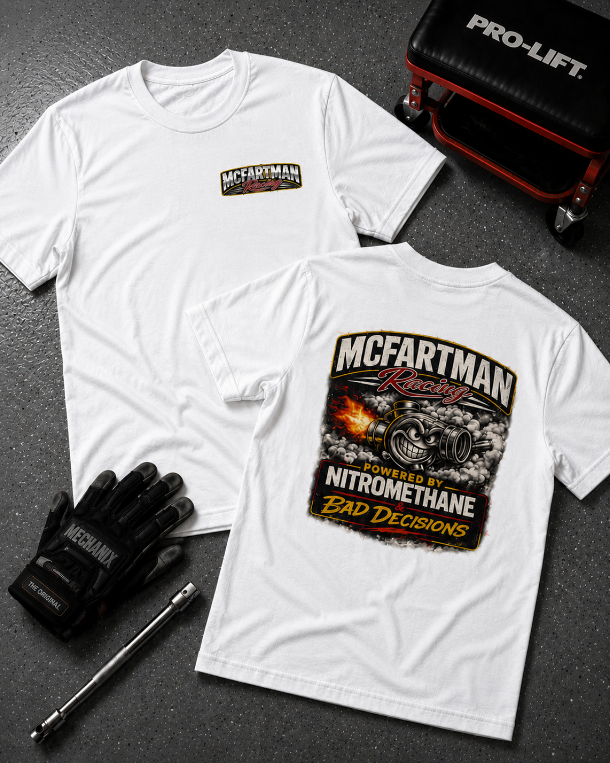 White t-shirt with 'McFartman Racing' design on a dark surface with gloves and tools.