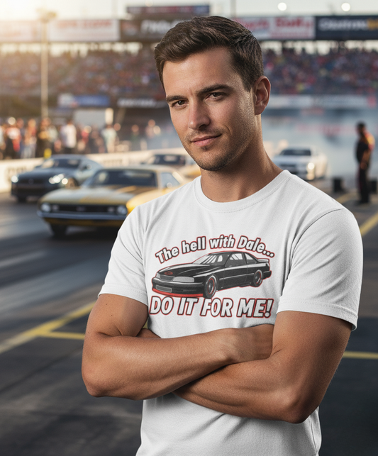 Man wearing a t-shirt with a car graphic and text 'The hell with Dale Do it for me' at a race track.