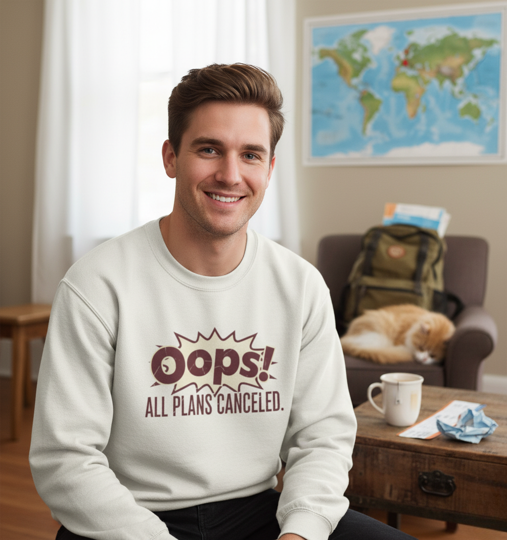 Man wearing a sweatshirt with 'Oops! All plans canceled.' text in a living room.
