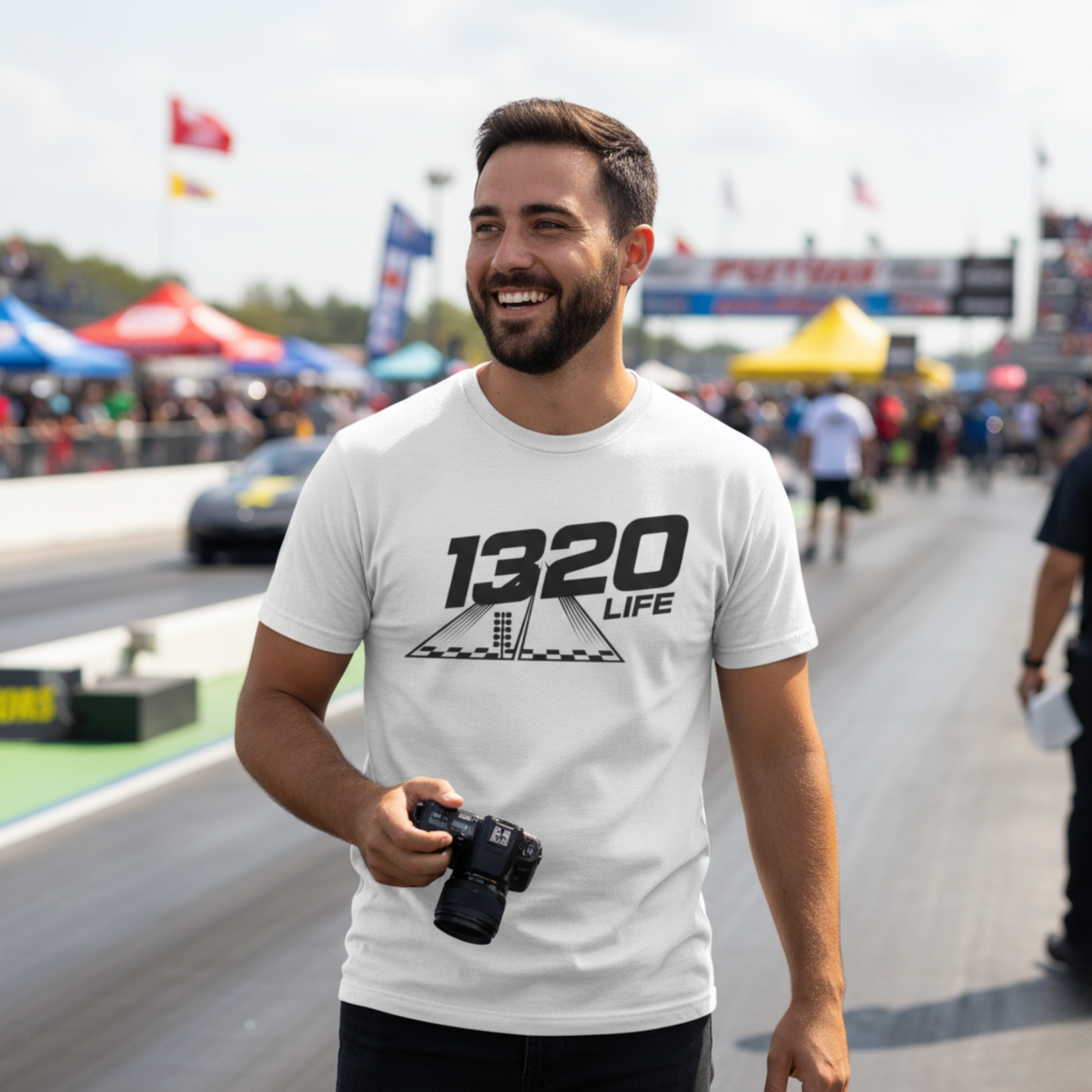 Man wearing a white t-shirt with '1320 LIFE' at a race track event