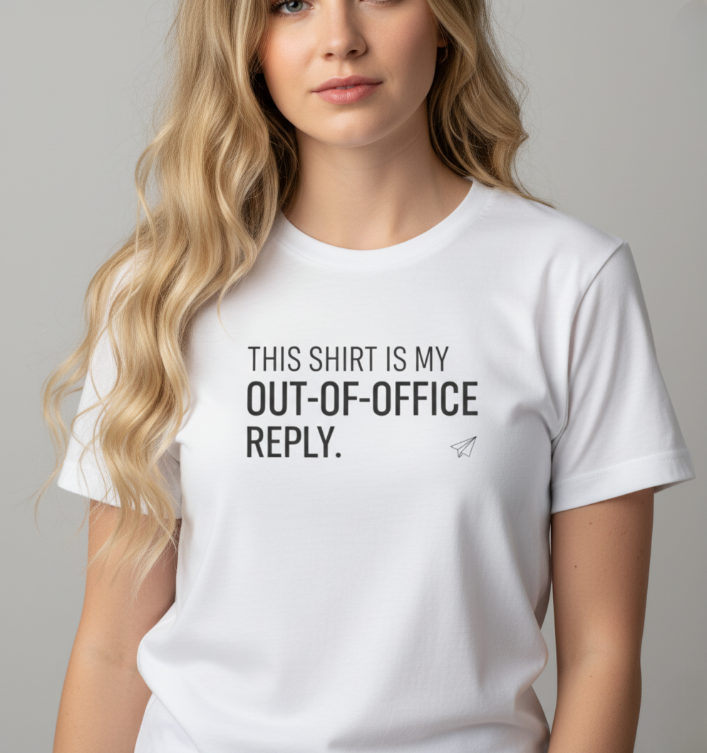 Person wearing a white t-shirt with text 'This shirt is my out-of-office reply' on a plain background