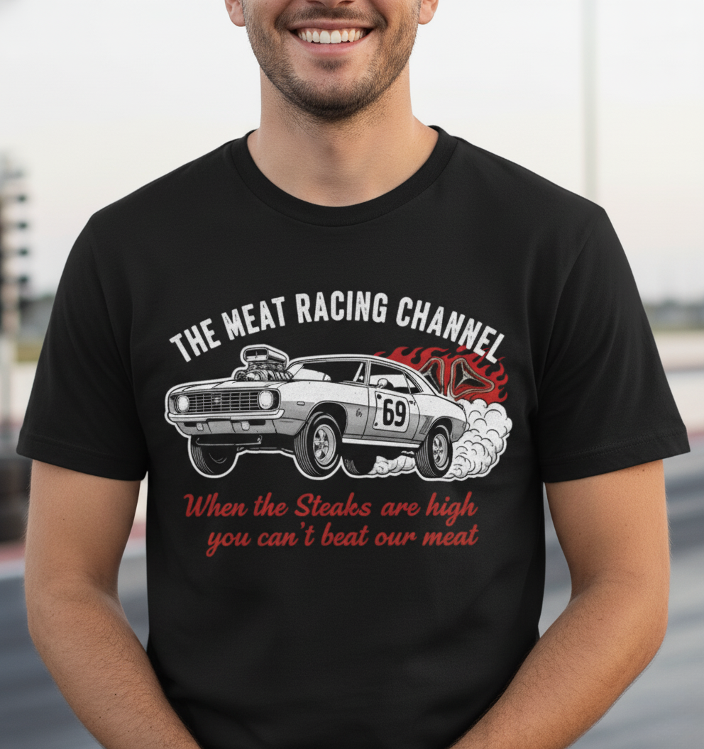 Person wearing a black Bella+Canvas 3001 T‑shirt featuring a bold drag racing graphic. The design shows a vintage muscle car with the number 69, white smoke and red flames, the distressed white title “The Meat Racing Channel” above, and the red script tagline “When the Steaks are high you can’t beat our meat” below. Funny drag racing parody shirt with retro hot rod style, perfect for car enthusiasts, gearheads, and humor‑driven racing apparel fans.