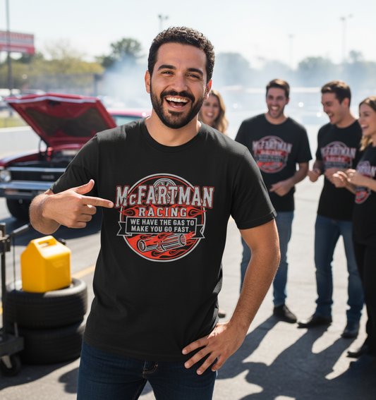 Man wearing a black t-shirt with 'McFarman Racing' design, standing in front of a group of people at a drag racing event.