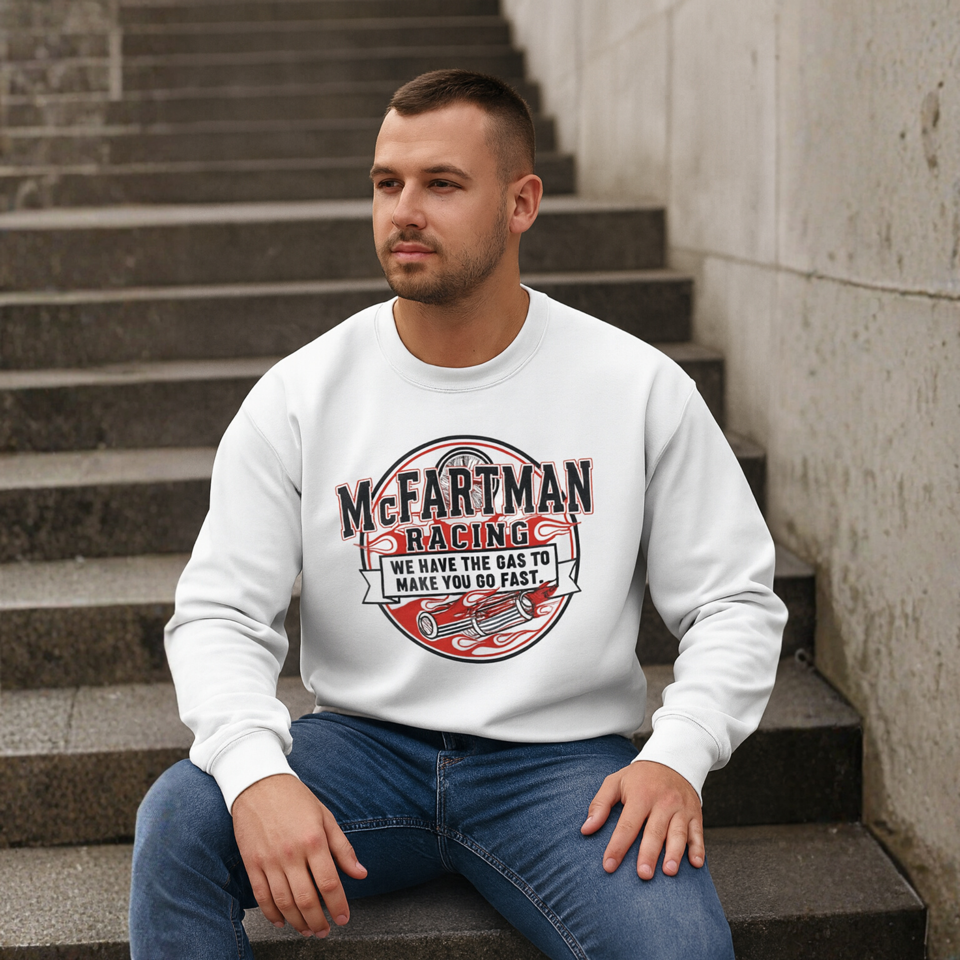 Man wearing a white sweatshirt with 'McFartman Racing' design sitting on steps.