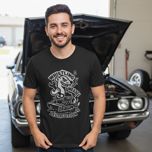 Man wearing a black t-shirt with graphic design of a cartoon weasel holding a wrench behind a flame-spitting muscle car with “Whistling Weasel Destruction” text in front of a classic car.