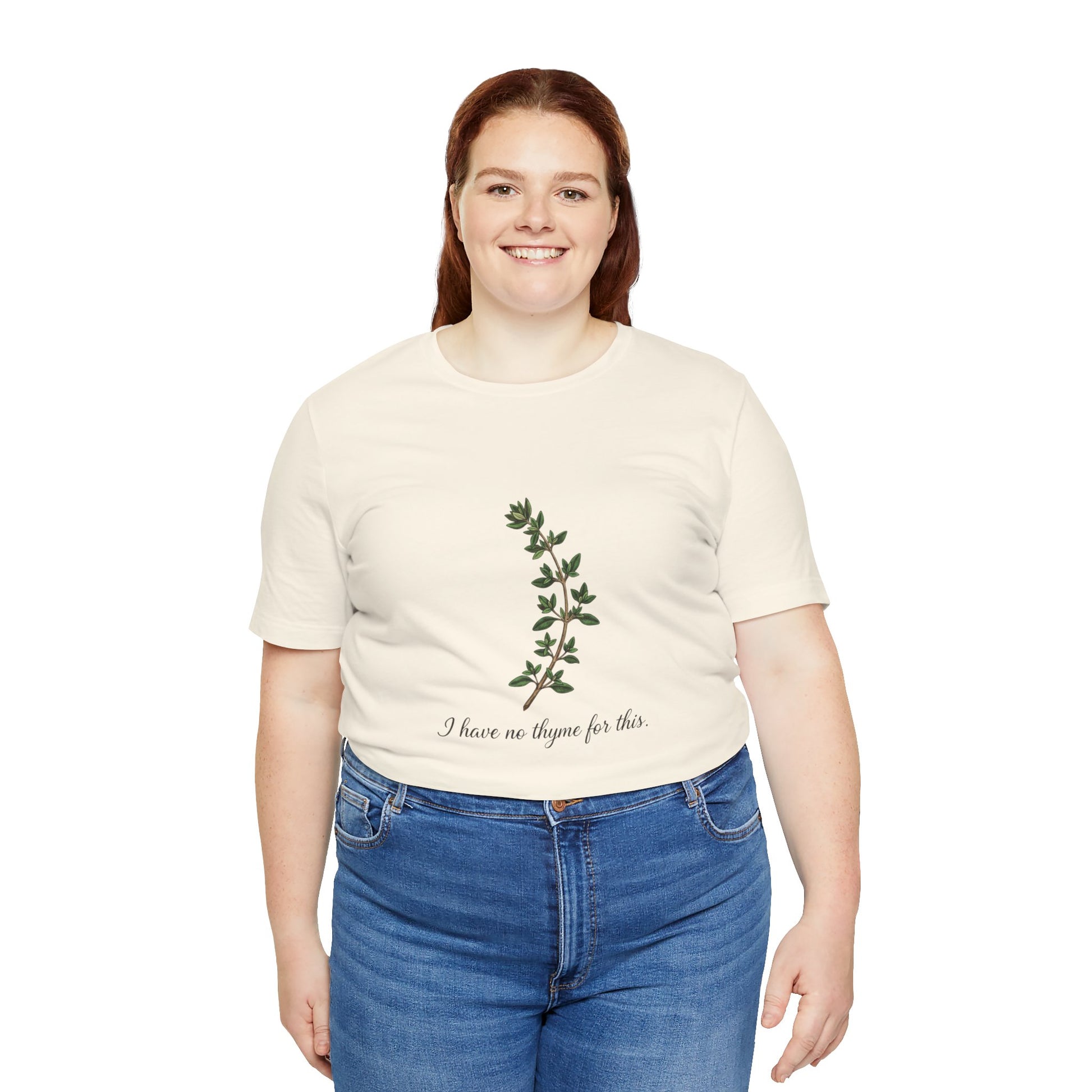 Person wearing a beige t-shirt with a plant design and text 'I have no thyme for this' on a white background