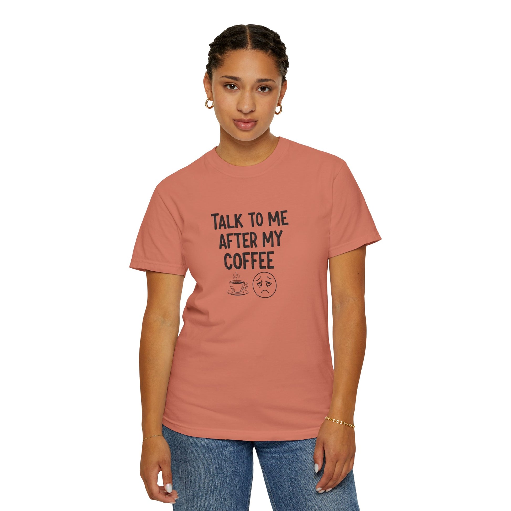 Person wearing a pink t-shirt with text 'Talk to me after my coffee' and graphics on a white background