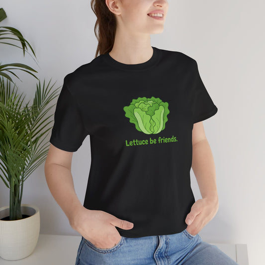 Person wearing a black t-shirt with a lettuce graphic and text 'Lettuce be friends', standing indoors.