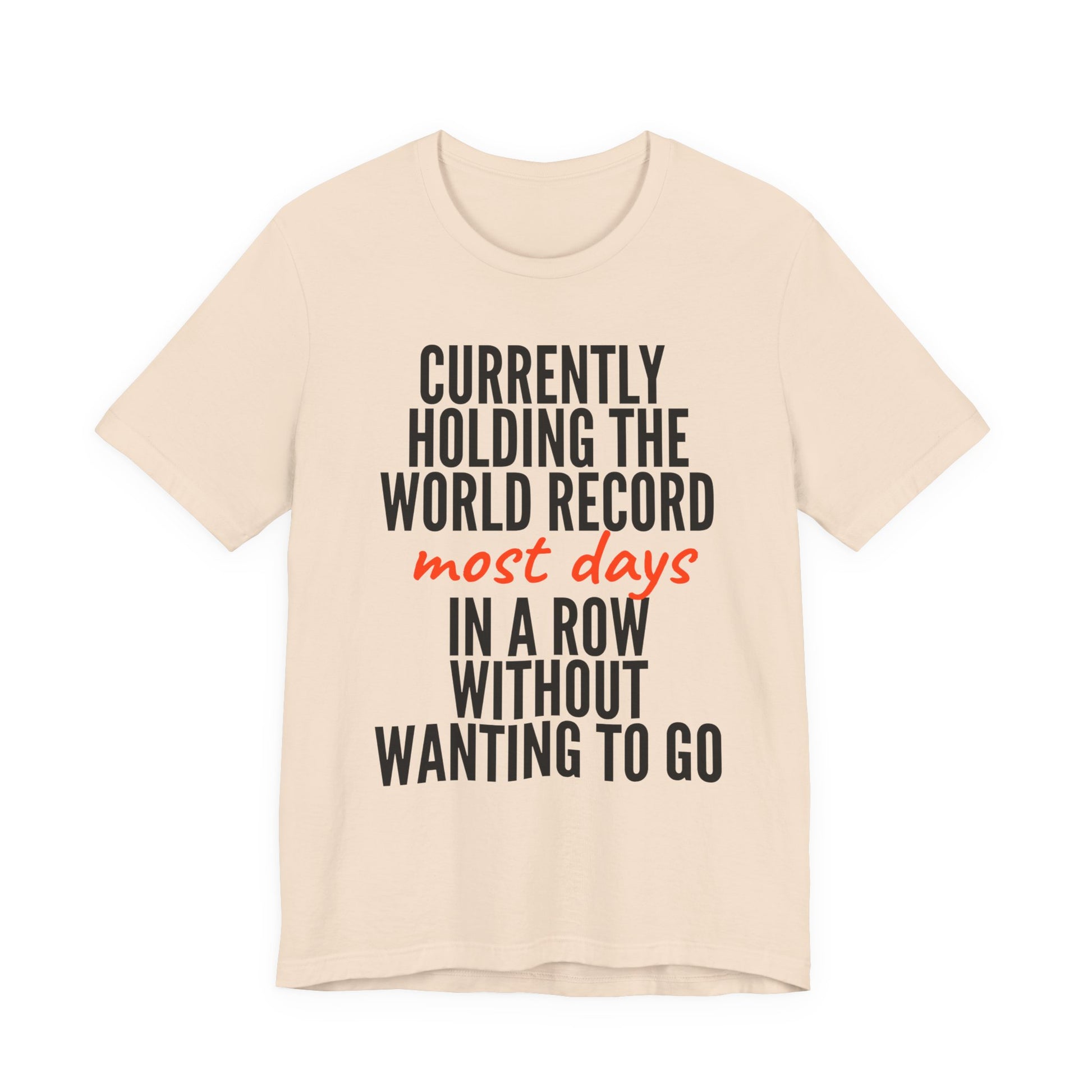 Beige t-shirt with humorous text  'Currently holding the world record most days in a row without wanting to go' design on a white background