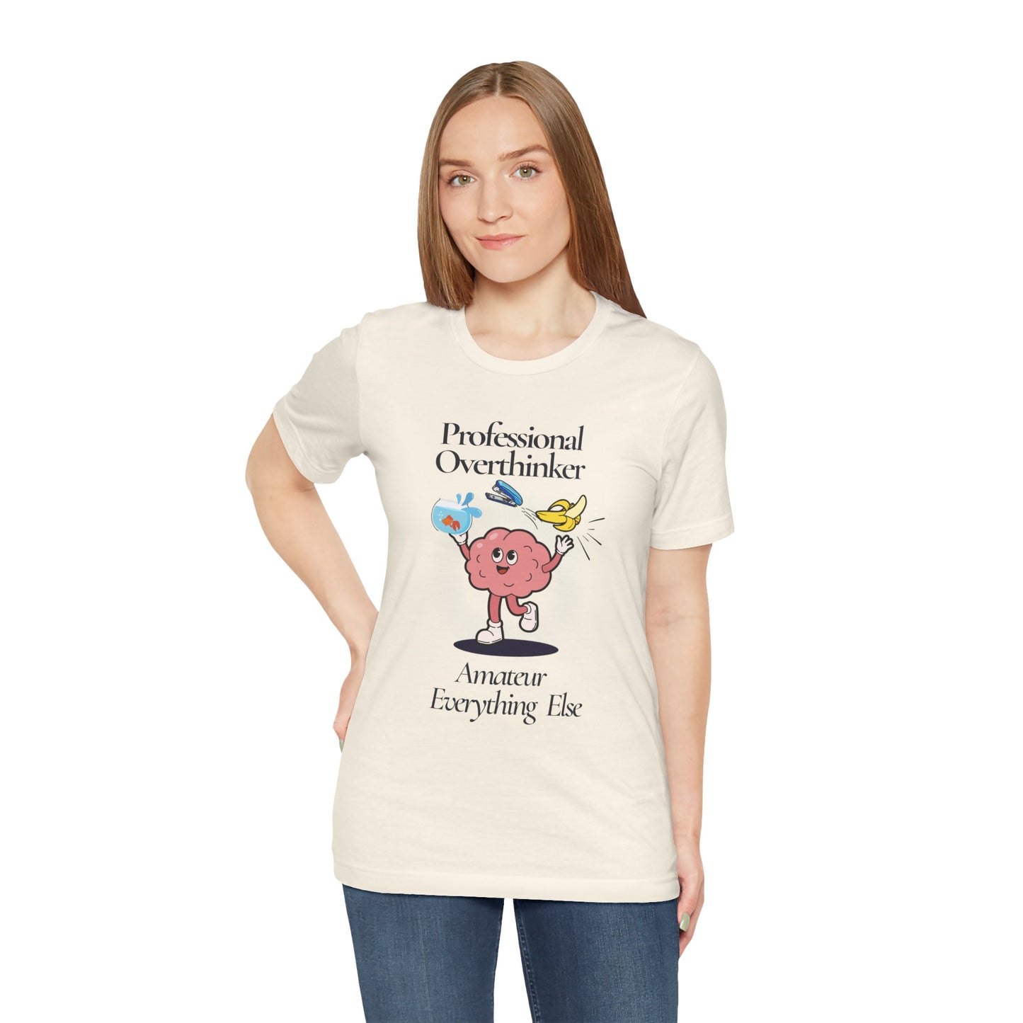 Woman wearing a cream t-shirt with a graphic and text 'Professional Overthinker, Amateur Everything Else' on a white background
