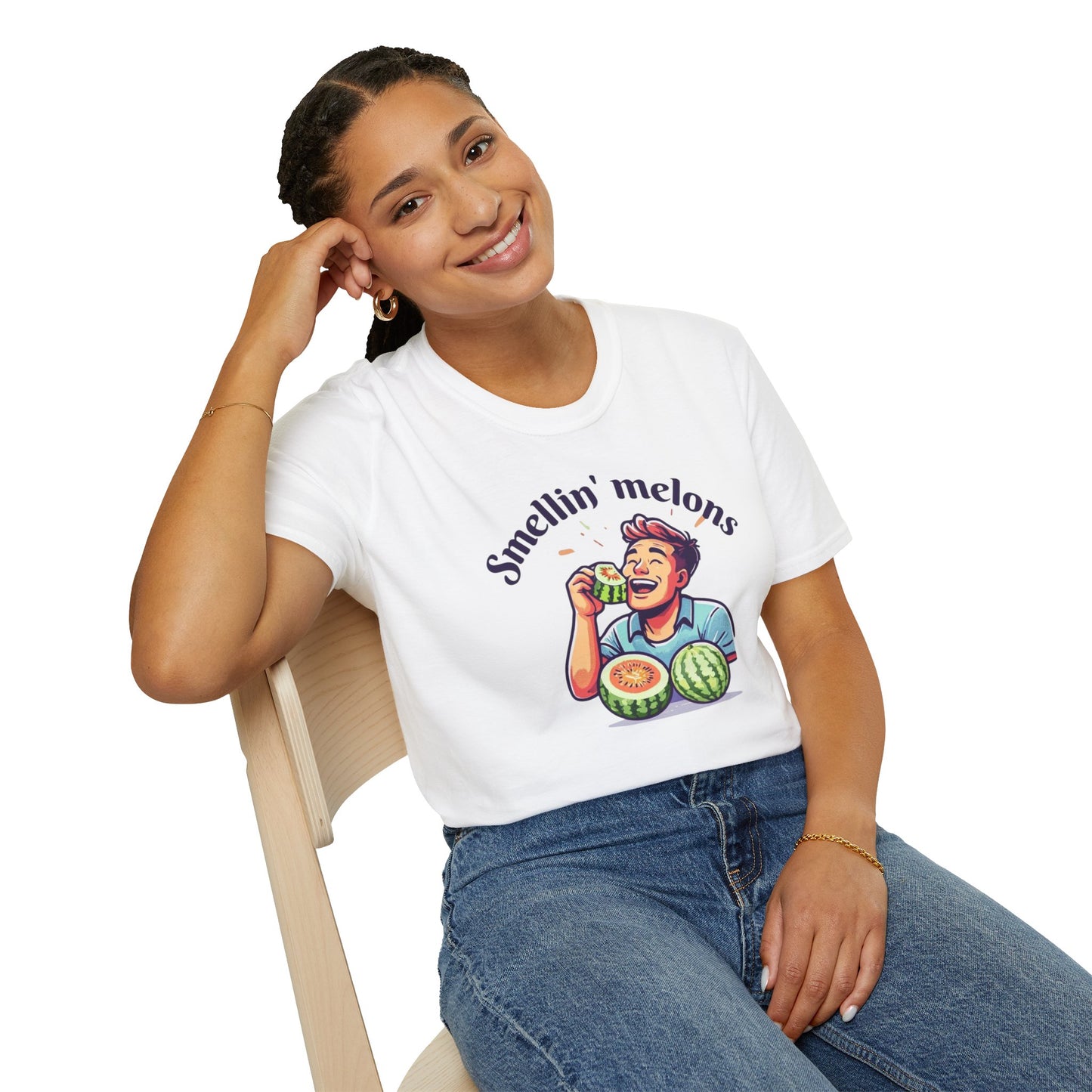 Person wearing a white t-shirt with a graphic design and text 'Smellin' melons' sitting on a chair.
