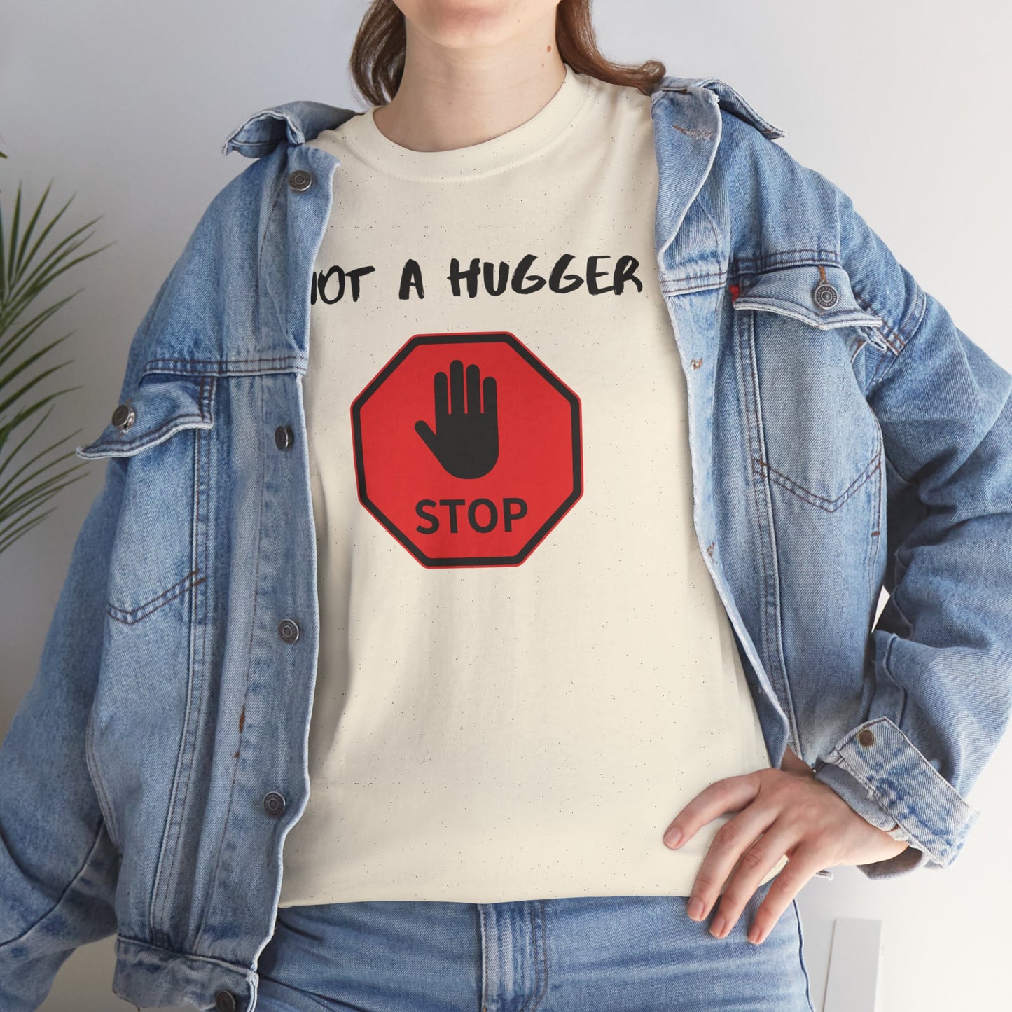 Person wearing a white t-shirt with a stop sign graphic and text 'NOT A HUGGER', paired with a denim jacket.