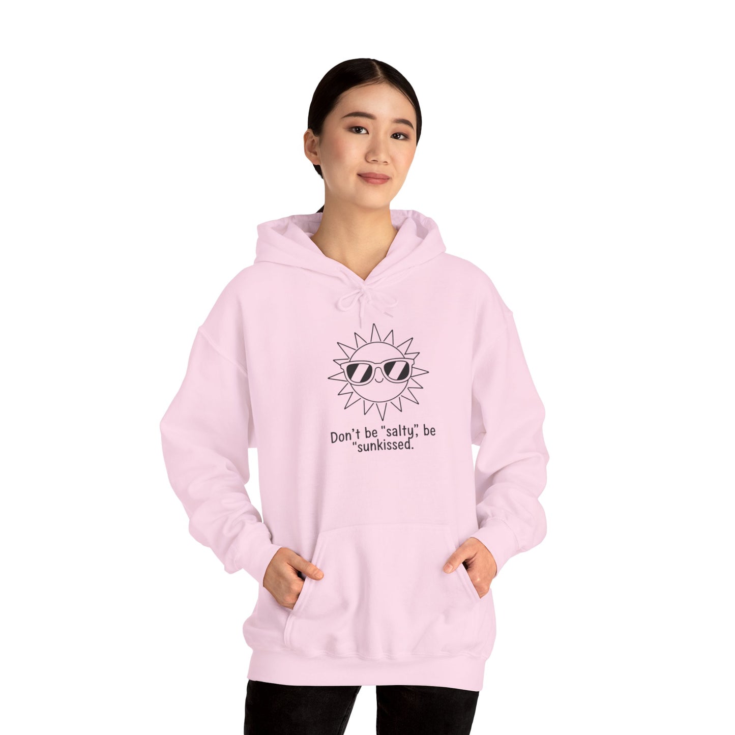 Person wearing a pink hoodie with sunglasses and text 'Don't be salty, be sunkissed' design on a white background