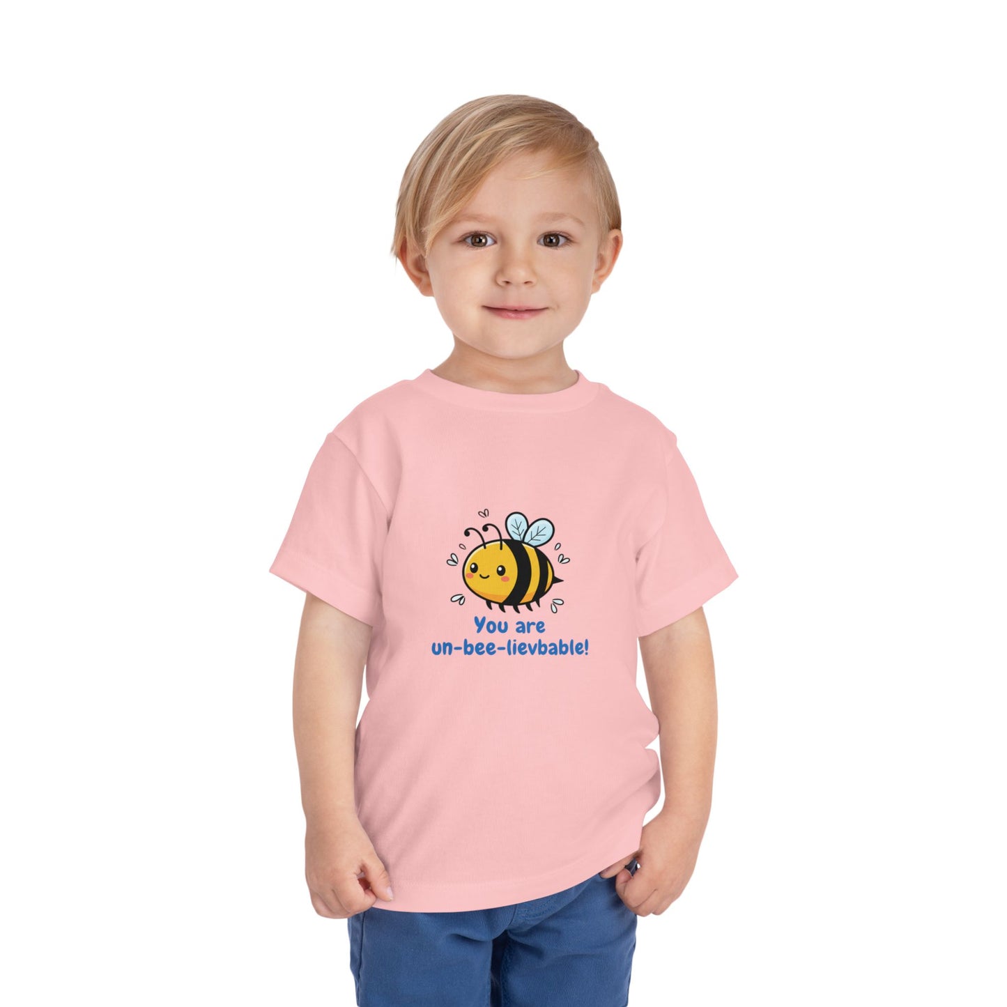 Child wearing a pink 'You Are Un-Bee-Lievable' toddler t-shirt with cute bee graphic – Bella+Canvas 3001T on a white background