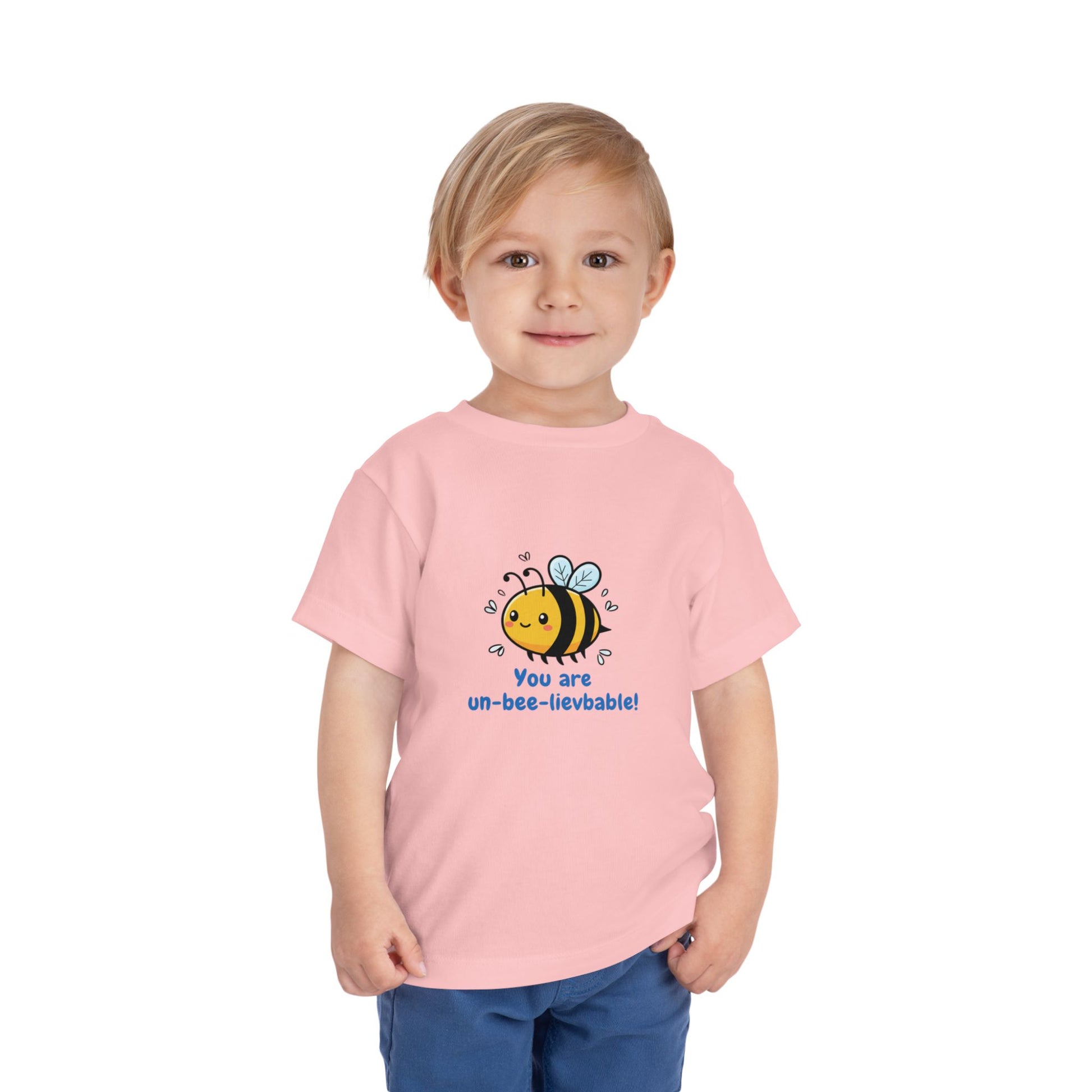 Child wearing a pink 'You Are Un-Bee-Lievable' toddler t-shirt with cute bee graphic – Bella+Canvas 3001T on a white background