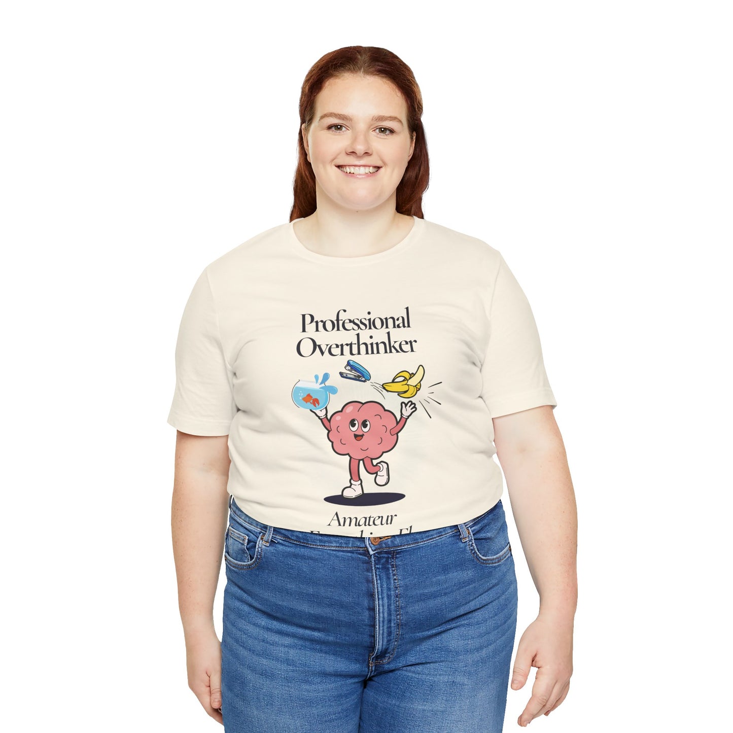 Person wearing a cream t-shirt with a graphic design and text 'Professional Overthinker, Amateur Everything Else', standing against a white background