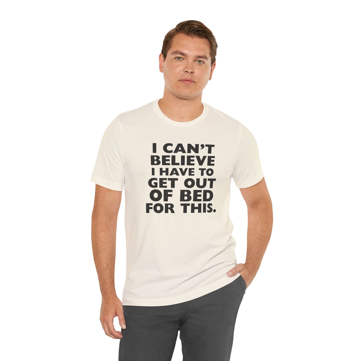Man wearing a natural t-shirt with black text 'I can't believe I have to get out of bed for this' on a white background