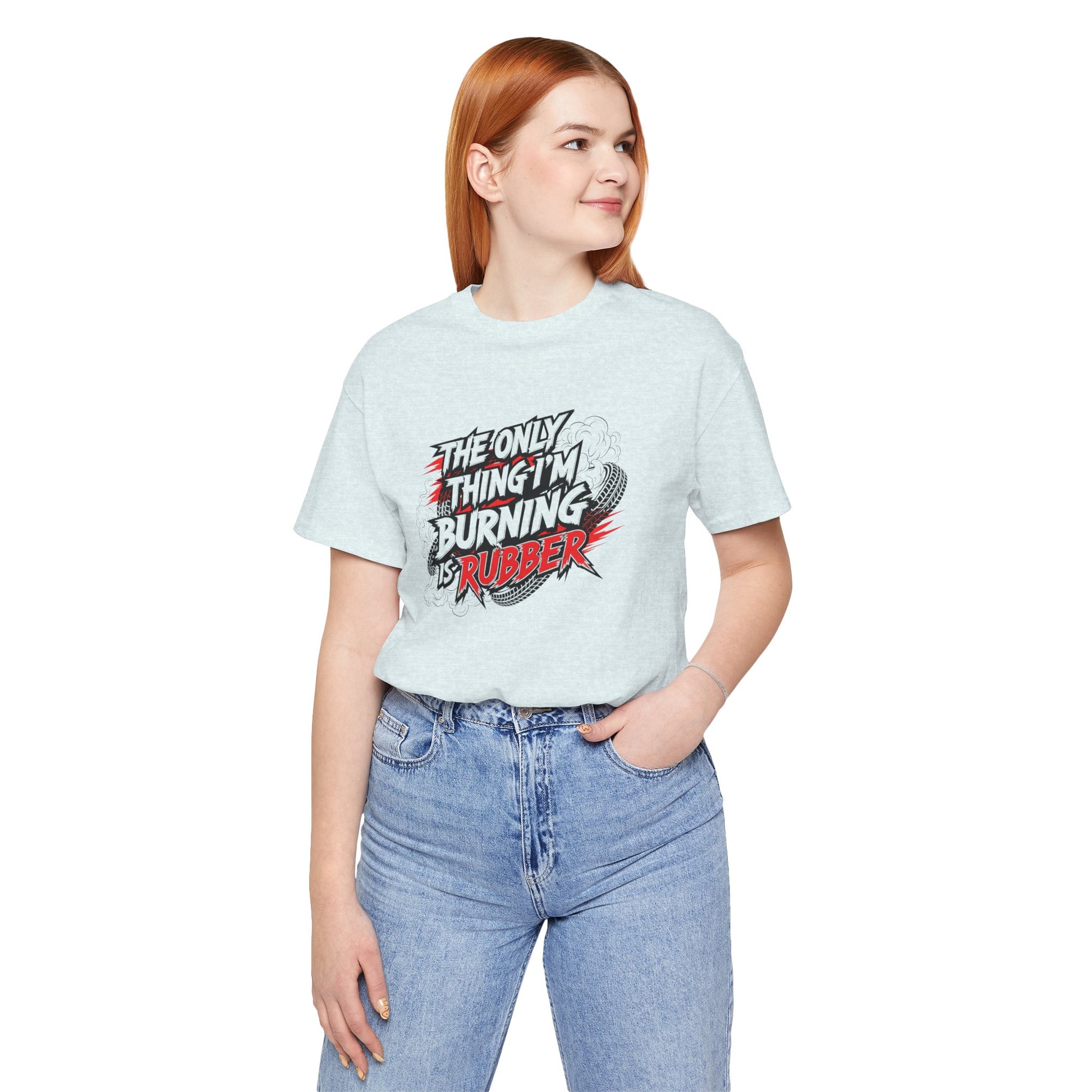 Person wearing a light blue t-shirt with a graphic design and text 'The only thing I'm burning is rubber', standing against a white background