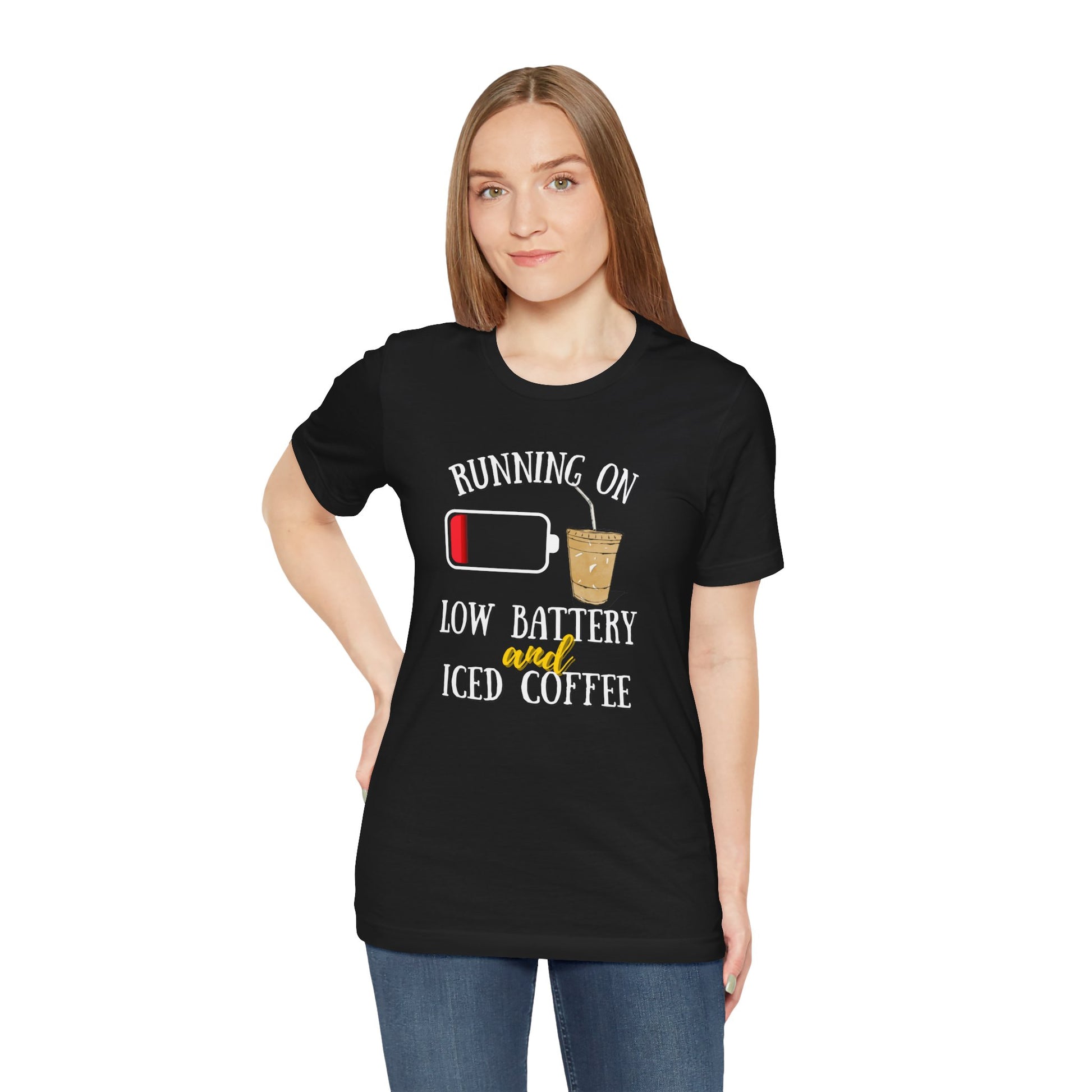 Person wearing a black t-shirt with text 'Running on low battery and iced coffee' and graphic design on a white background