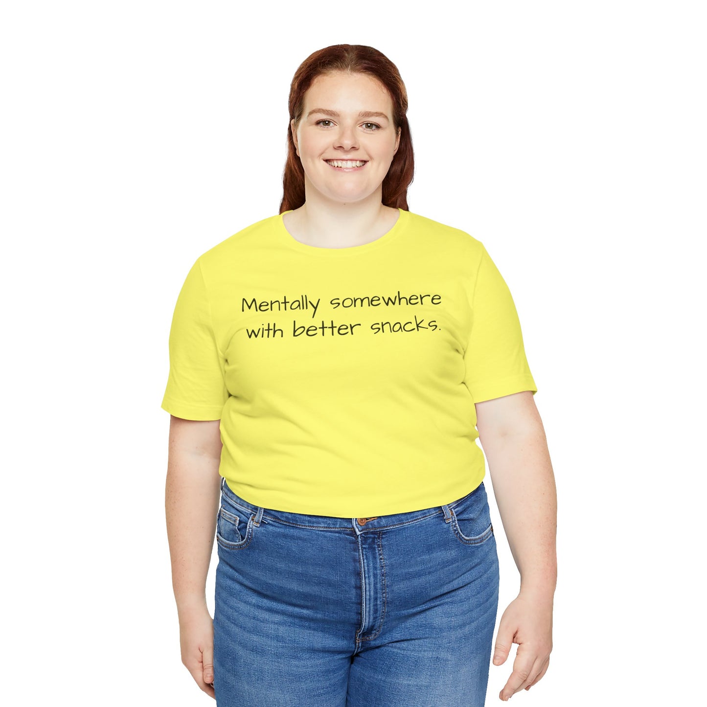 Person wearing a yellow t-shirt with text 'Mentally somewhere with better snacks' on a white background