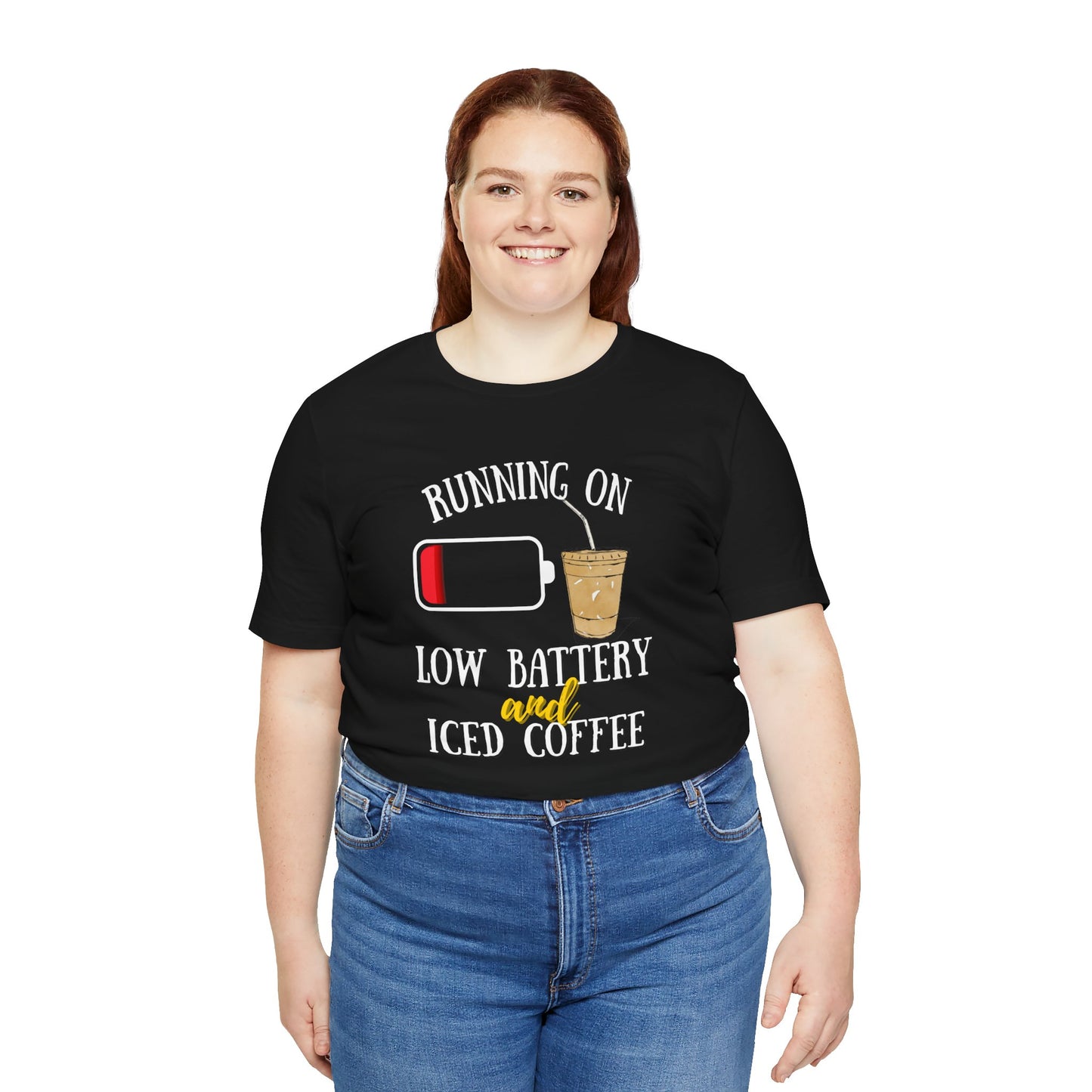 Person wearing a black t-shirt with 'Running on low battery and iced coffee' text and graphics.