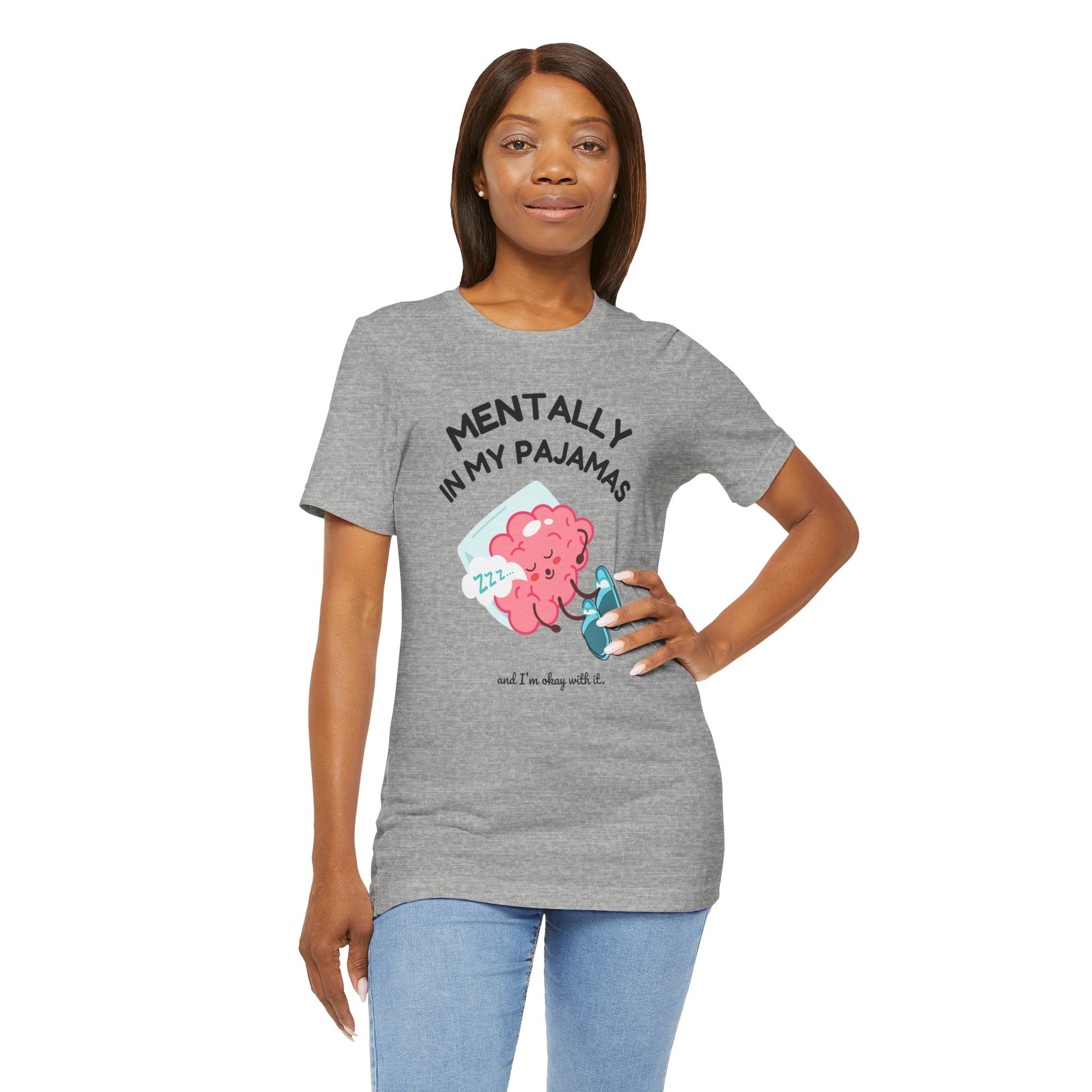 Woman wearing a gray t-shirt with a graphic and text 'Mentally in my pajamas and I'm ok with it', standing against a white background