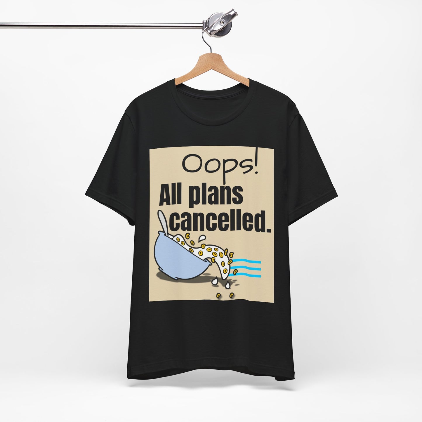 Black t-shirt with graphic and text 'Oops! All plans cancelled.' on a hanger against a white background