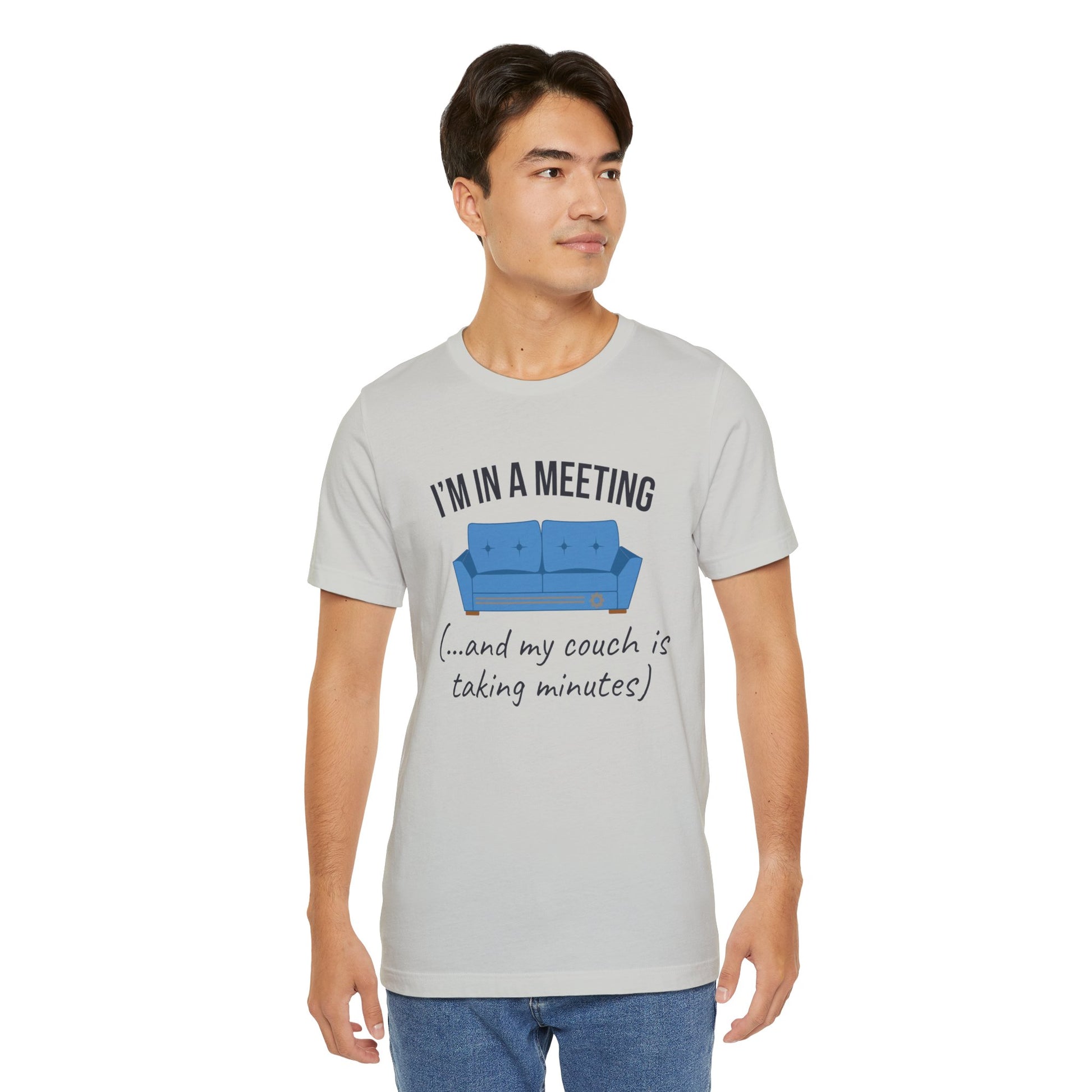 Man wearing a gray t-shirt with a graphic and text 'I'm in a meeting (...and my couch is taking minutes)'on a white background