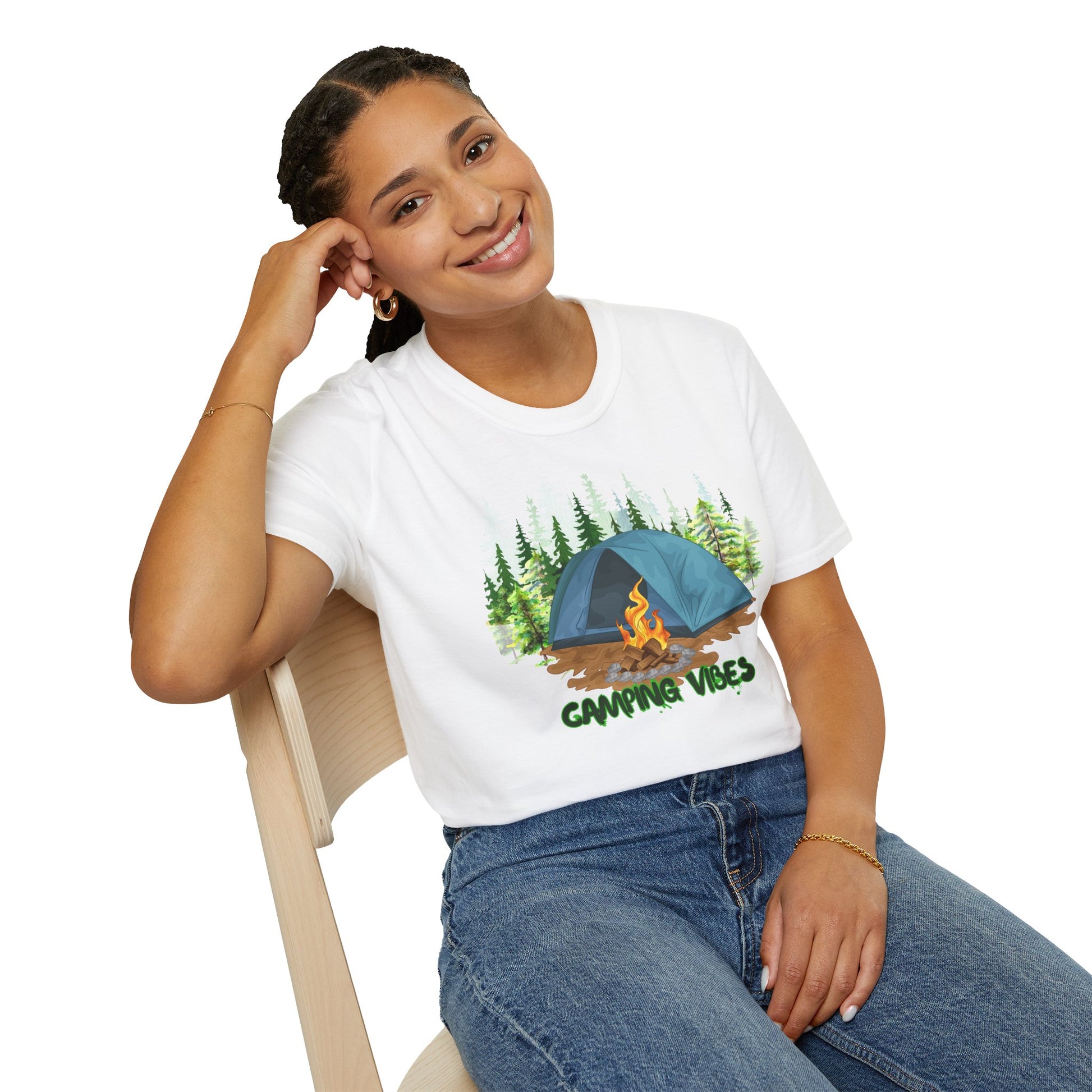 Person wearing a white t-shirt with a camping design and text, sitting on a chair.
