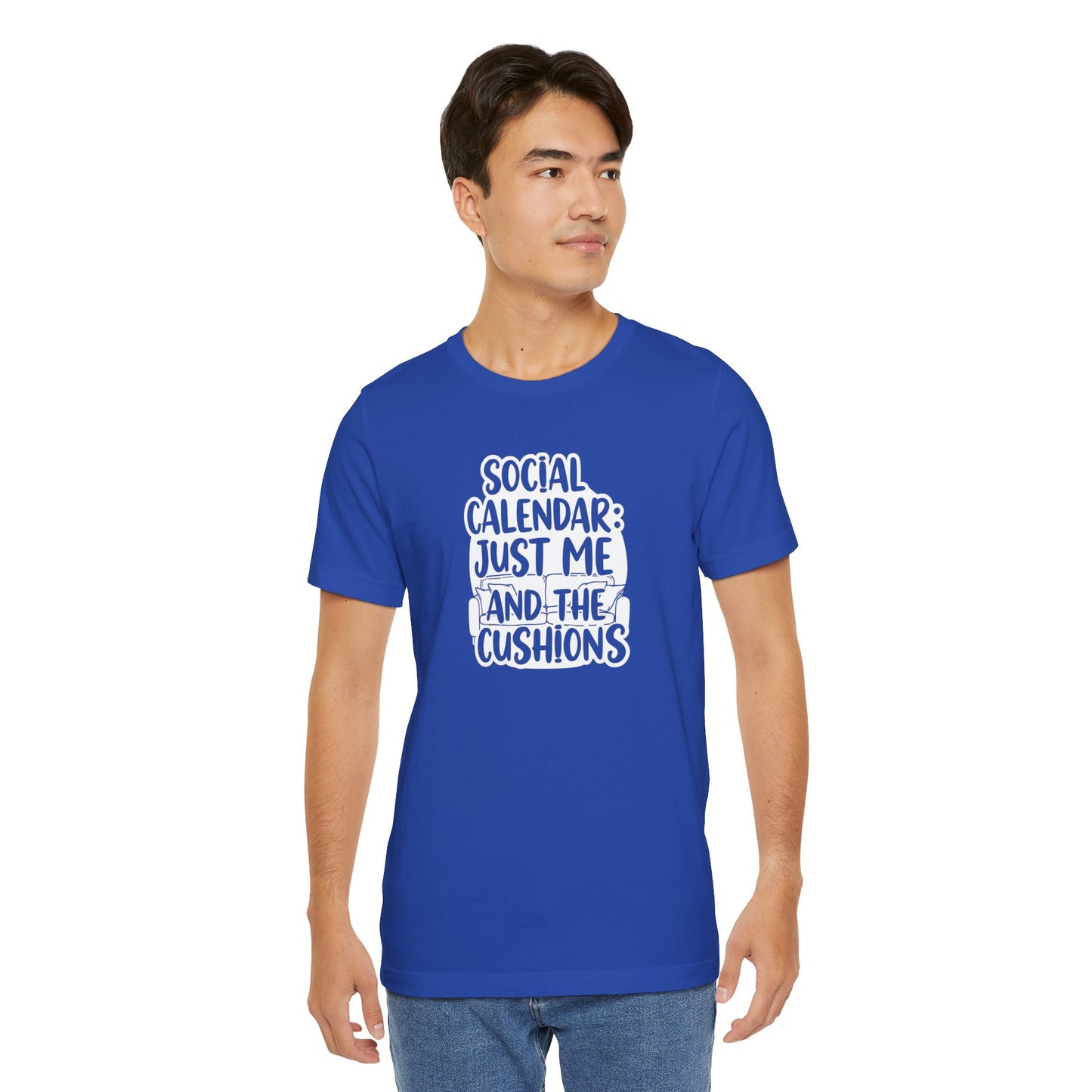 Man wearing a blue t-shirt with white text 'Social calendar: Just me and the cushions' on a white background