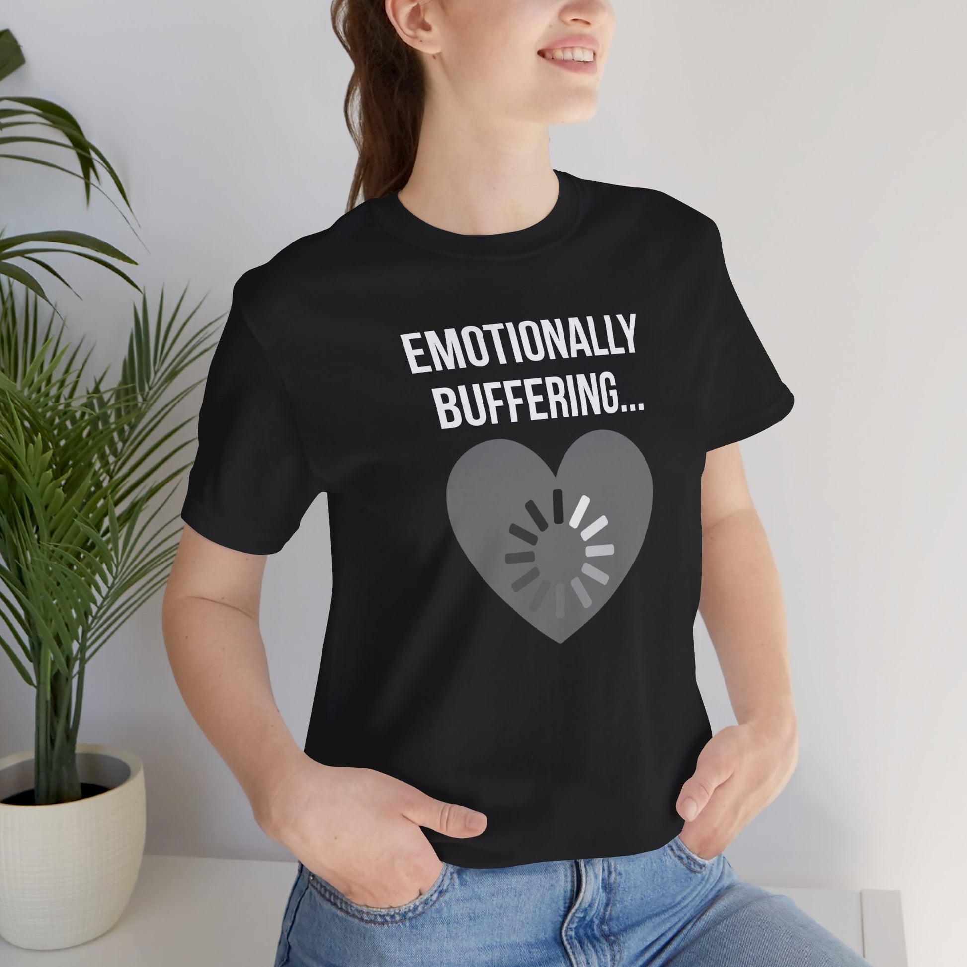 Person wearing a black t-shirt with 'Emotionally Buffering...' text and heart design.