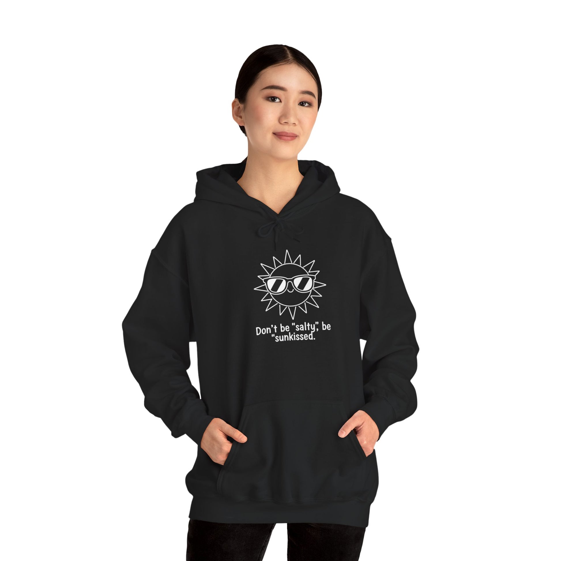 Person wearing a black hoodie with a sun graphic and text 'Don't be salty, be sunkissed' on a white background