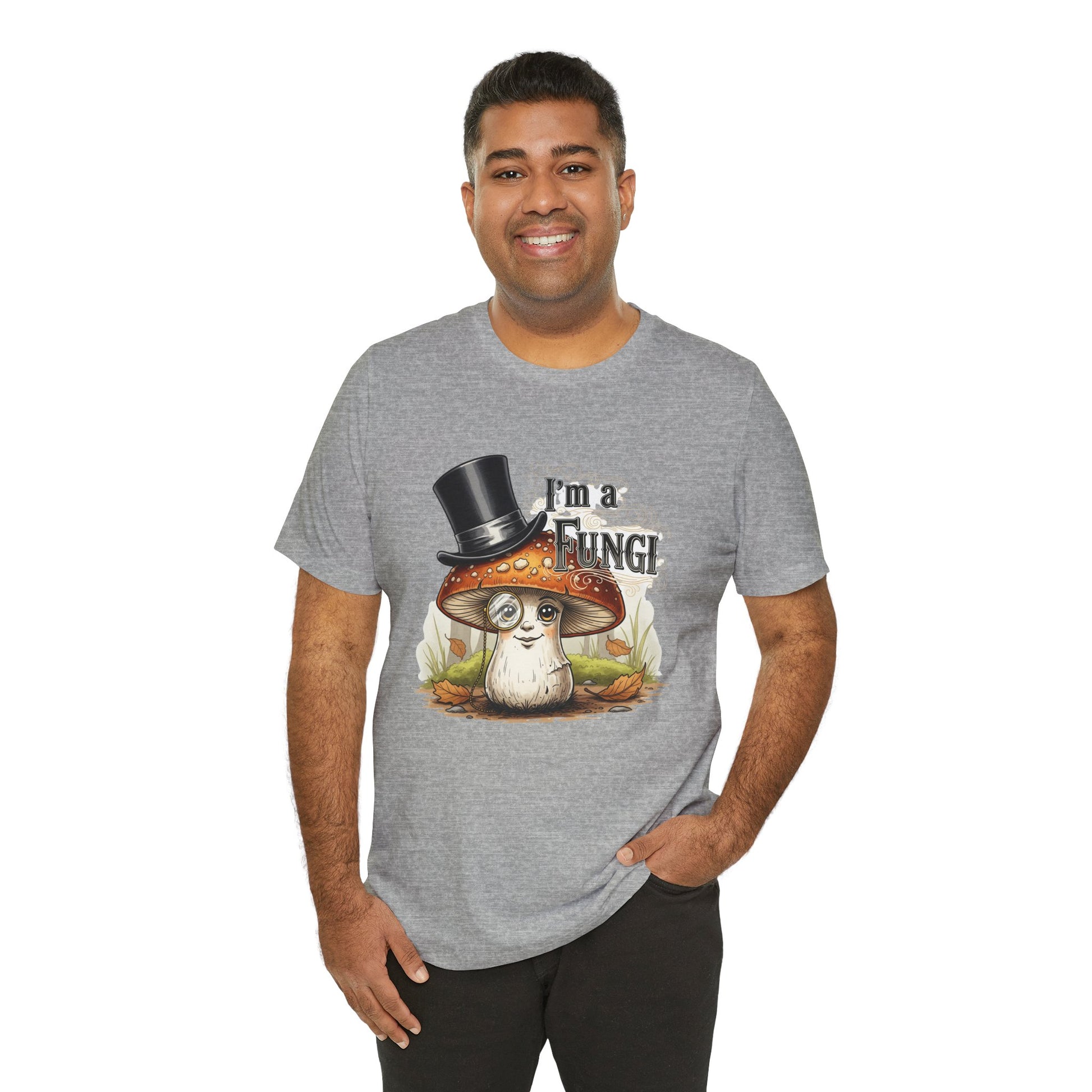 Athletic Heather Bella+Canvas 3001 unisex shirt showcasing a whimsical mushroom in a top hat and monocle, accented by autumn foliage and grass, with humorous “I’m a Fungi” text in a bold, fun font.