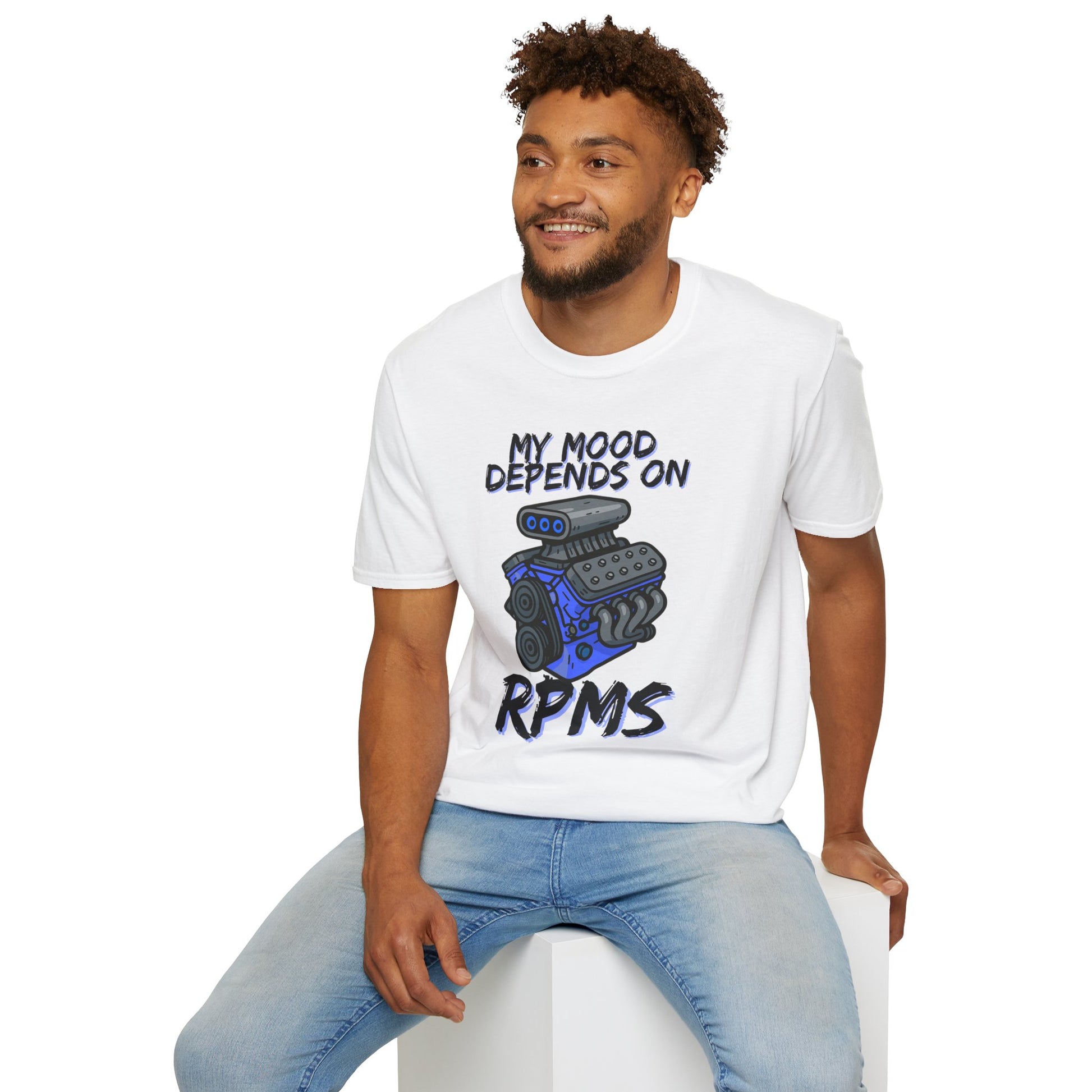 Man wearing a white t-shirt with a graphic and text, sitting on a white stool against a white background.