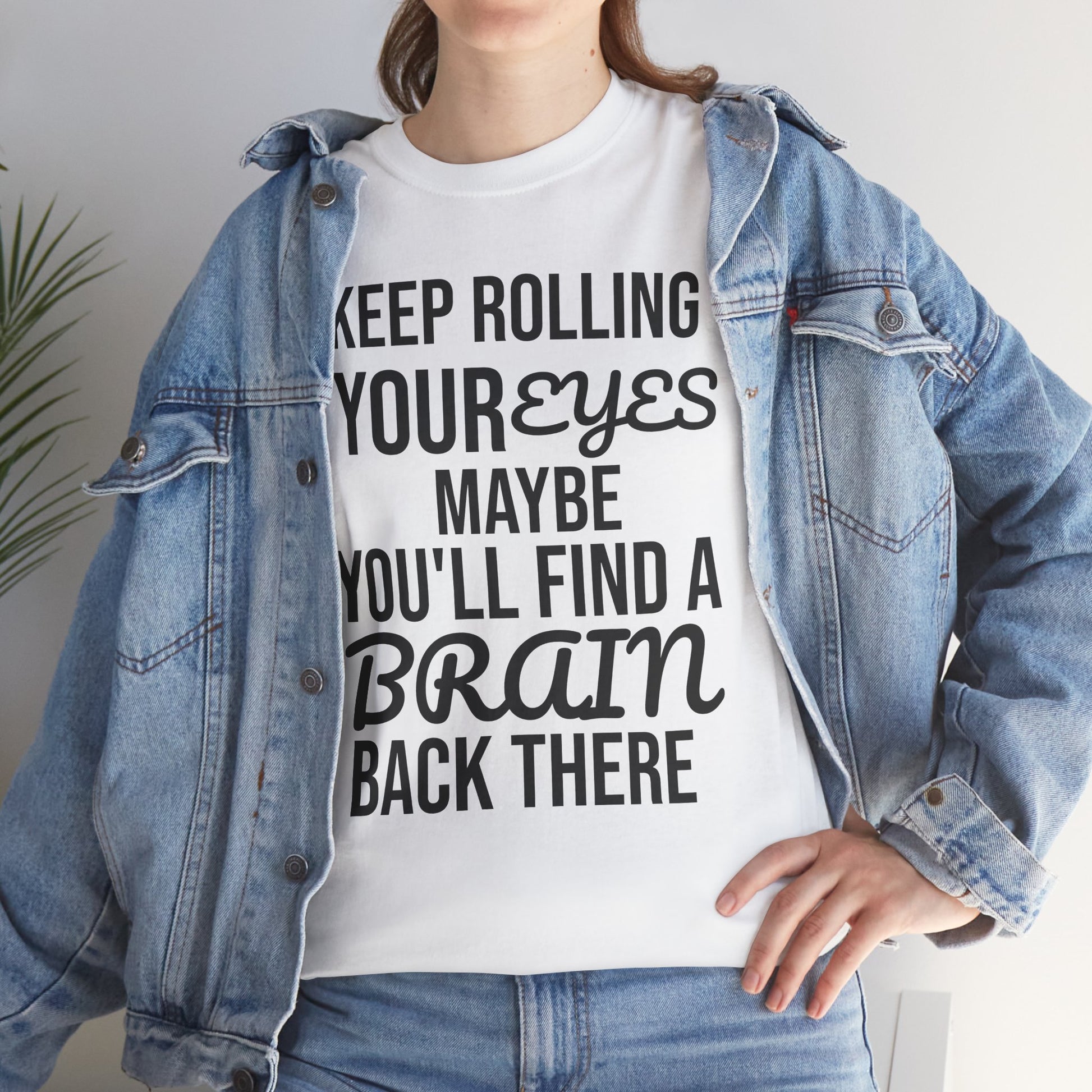 Person wearing a white t-shirt with humorous text 'KEEP ROLLING YOUR EYES MAYBE YOU'LL FIND A BRAIN BACK THERE' and a denim jacket.