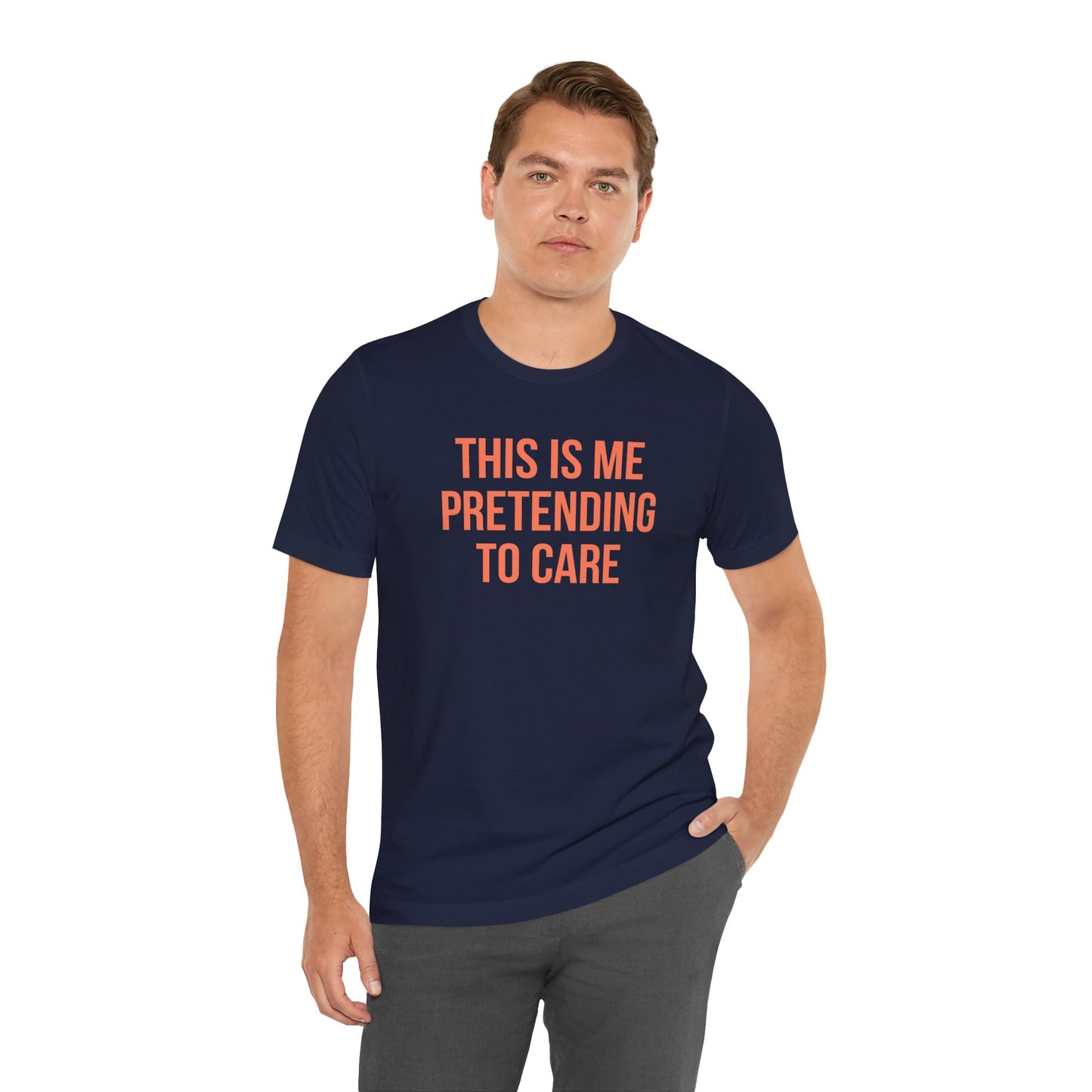 Man wearing a navy blue t-shirt with orange text 'This is me pretending to care' on a white background