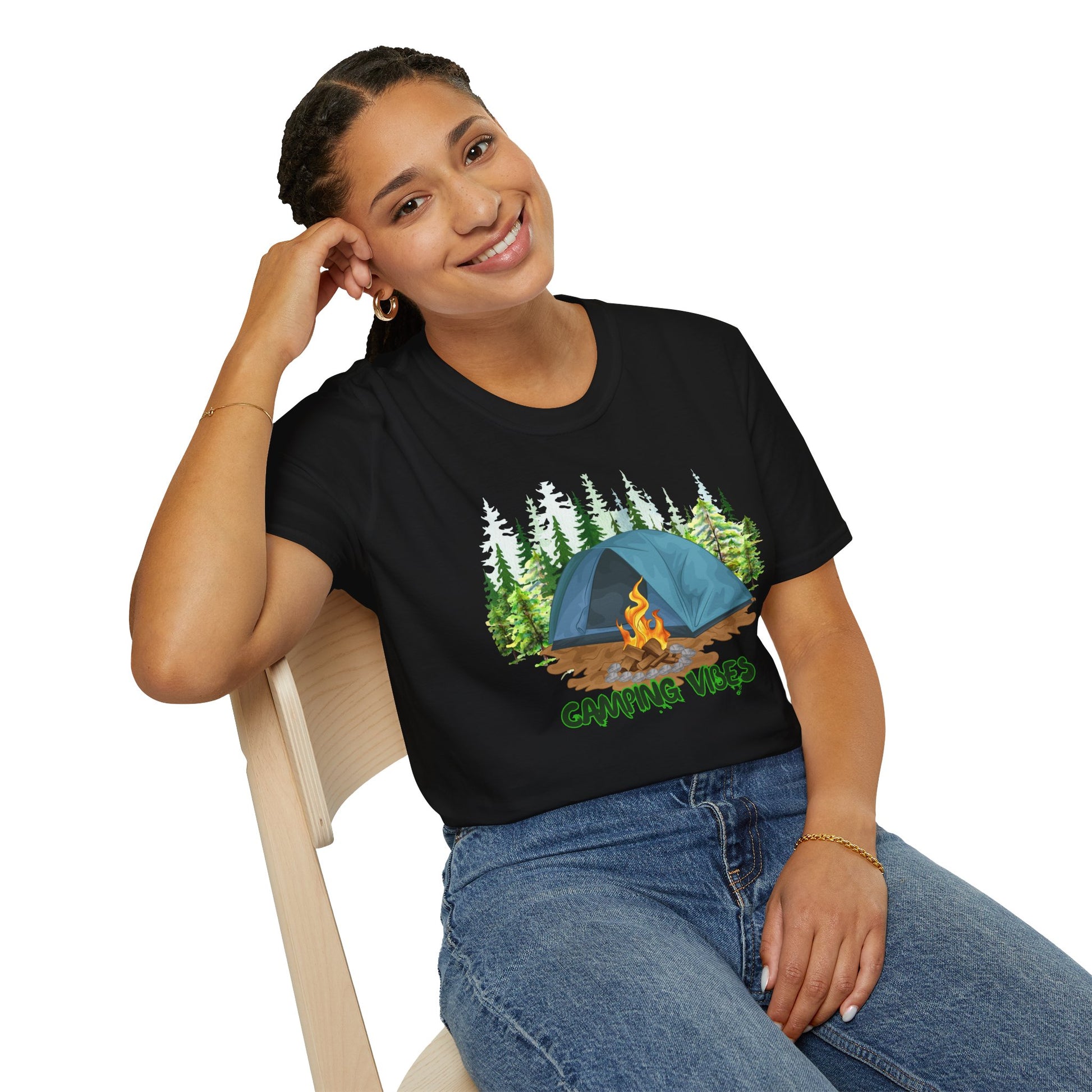 Person wearing a black t-shirt with a camping design, sitting on a chair.