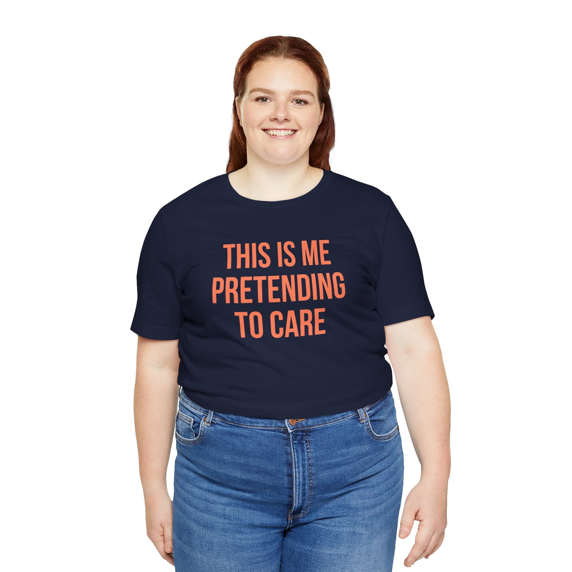 Person wearing a navy blue t-shirt with orange text 'This me pretending to care' on a white background