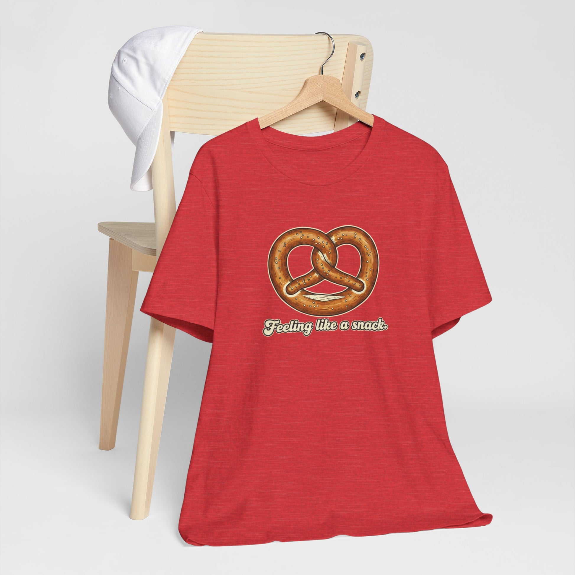 Red t-shirt with a pretzel graphic and text 'Feeling like a snack' on a white background