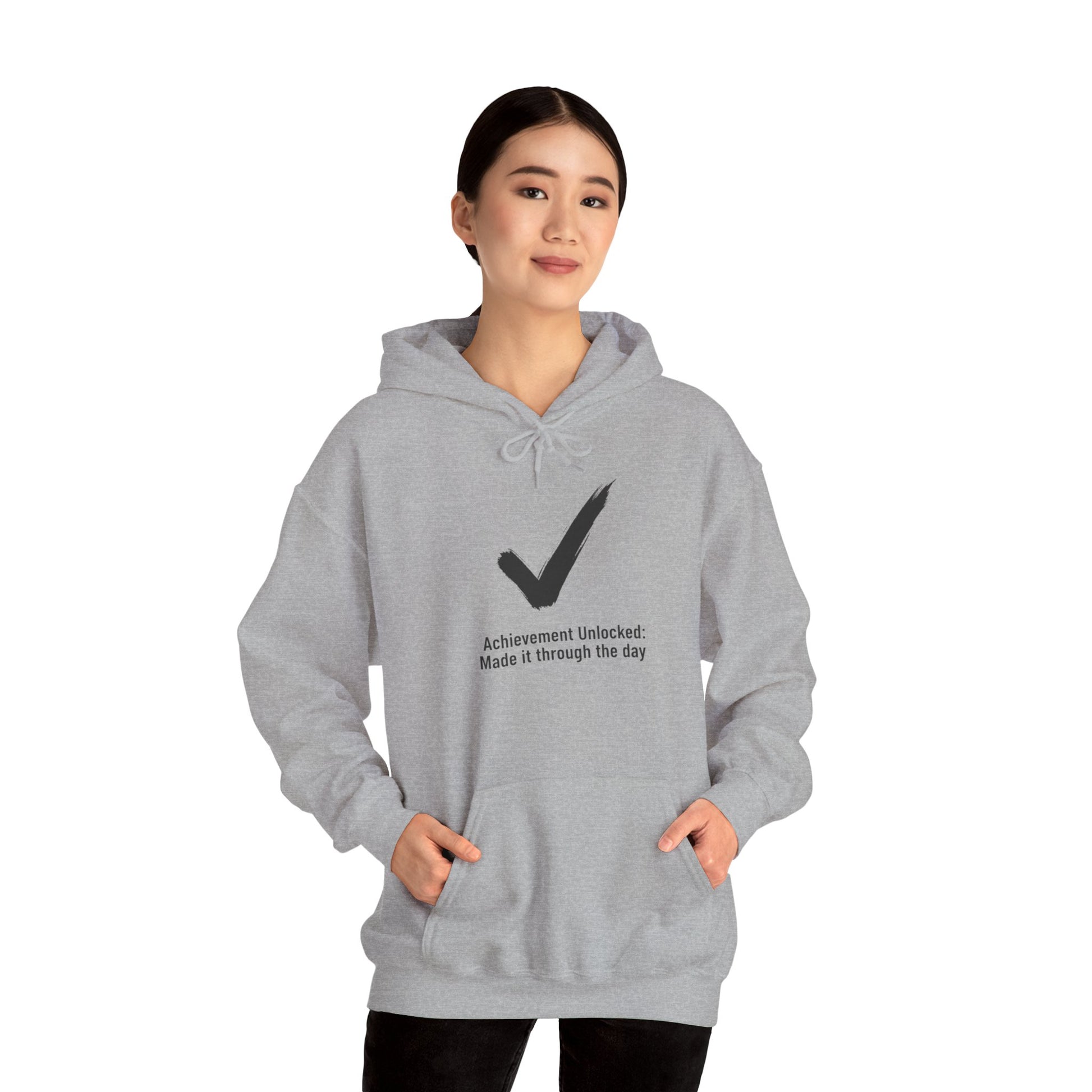 Person wearing a gray hoodie with a checkmark design and text 'Achievement Unlocked: Made it through the day' on a white background