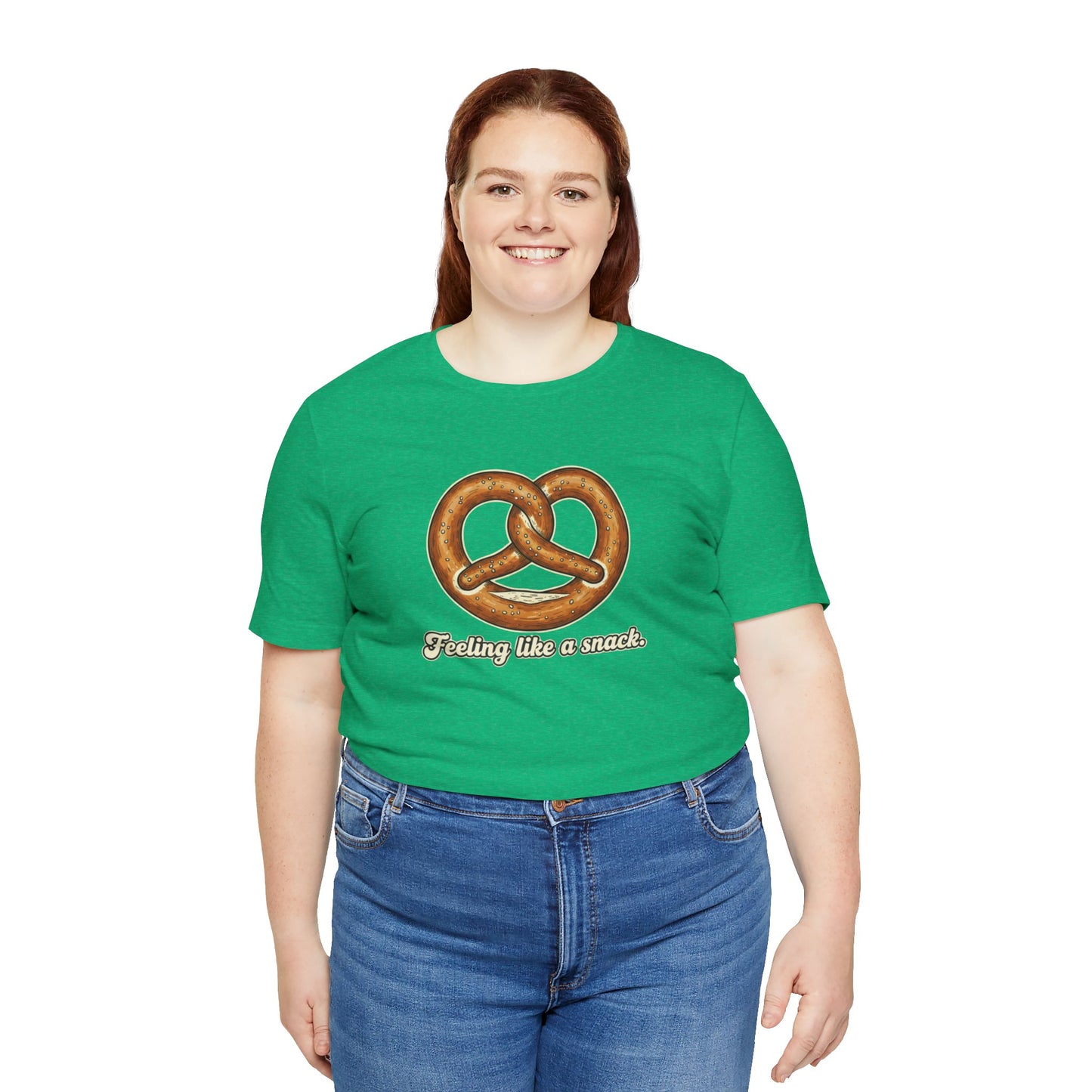 Person wearing a green t-shirt with a pretzel graphic and text 'Feeling like a snack' on a white background