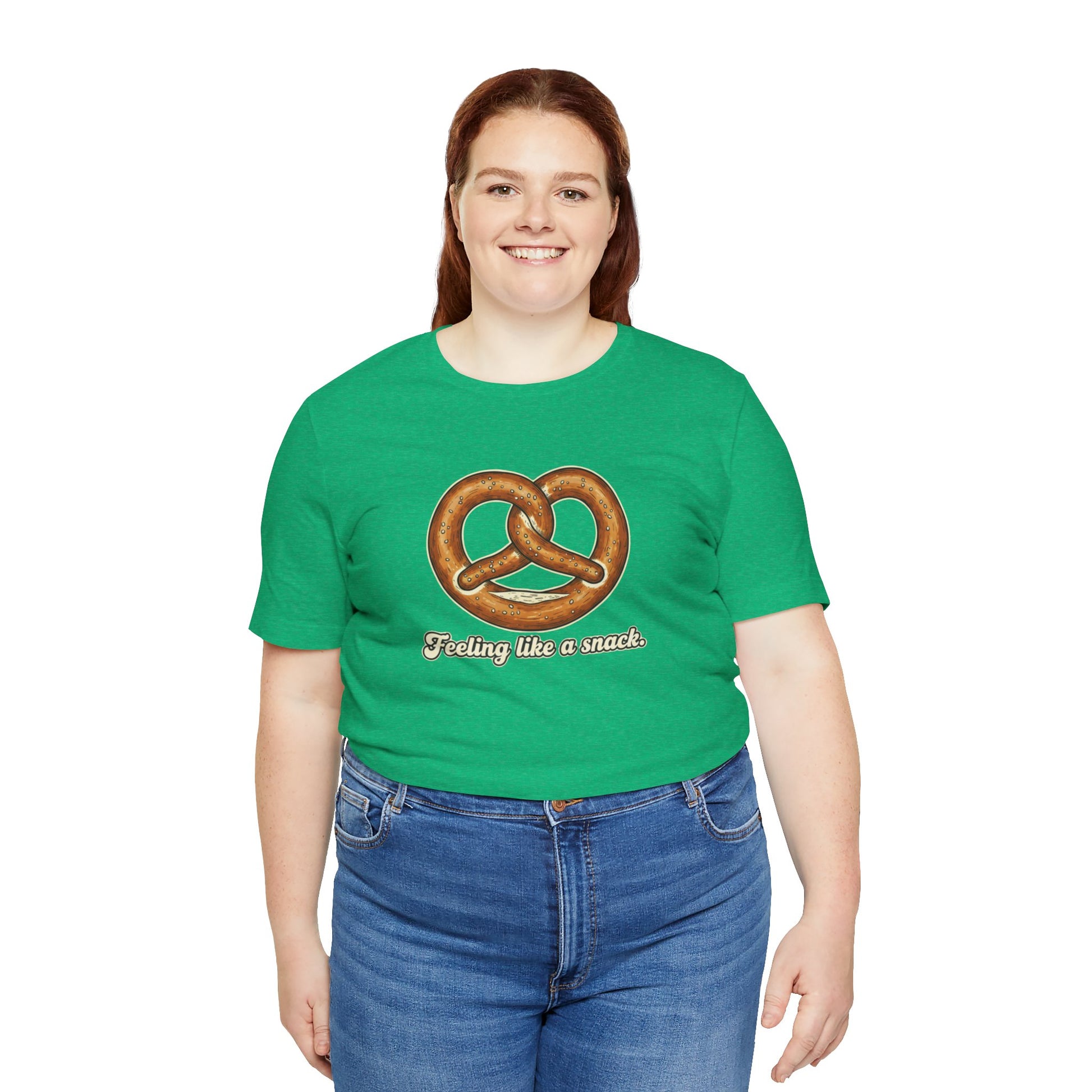 Person wearing a green t-shirt with a pretzel graphic and text 'Feeling like a snack' on a white background
