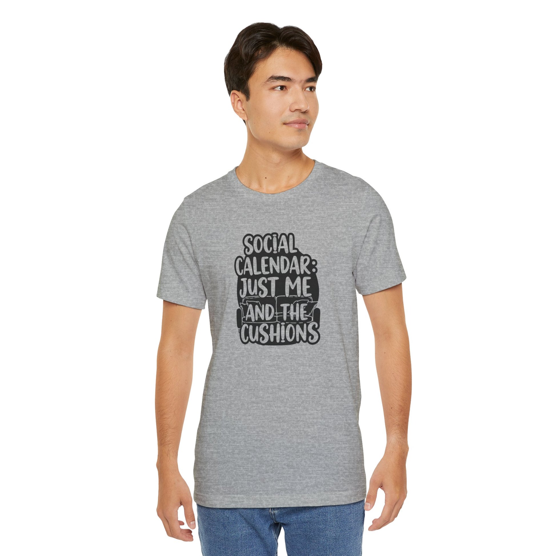 Man wearing a gray t-shirt with text 'Social calendar: Just me and the cushions' on a white background