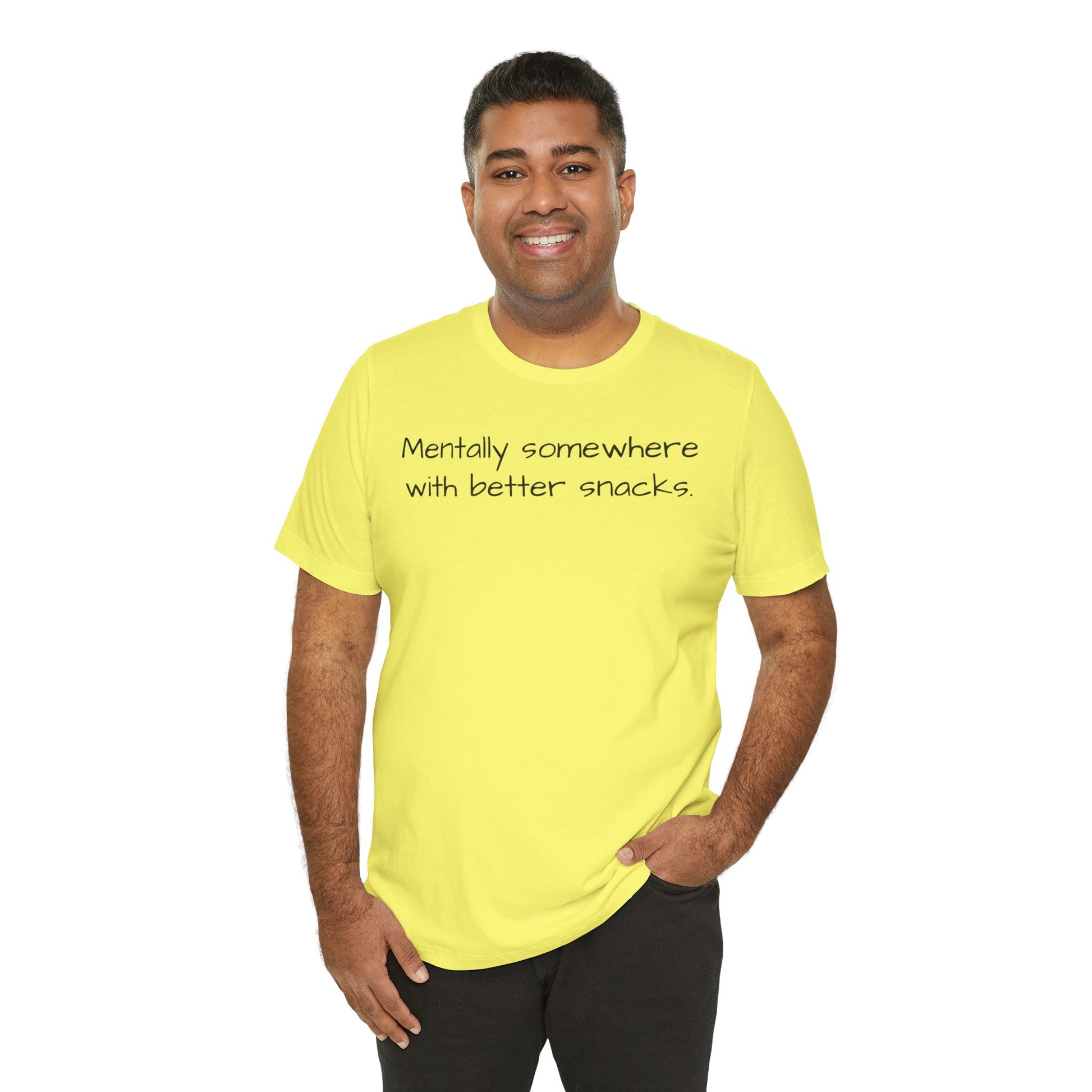 Man wearing a bright yellow t-shirt with text 'Mentally somewhere with better snacks' on a white background