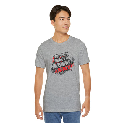 Man wearing a gray t-shirt with a graphic design and text 'The only thing I'm burning is rubber' on a white background