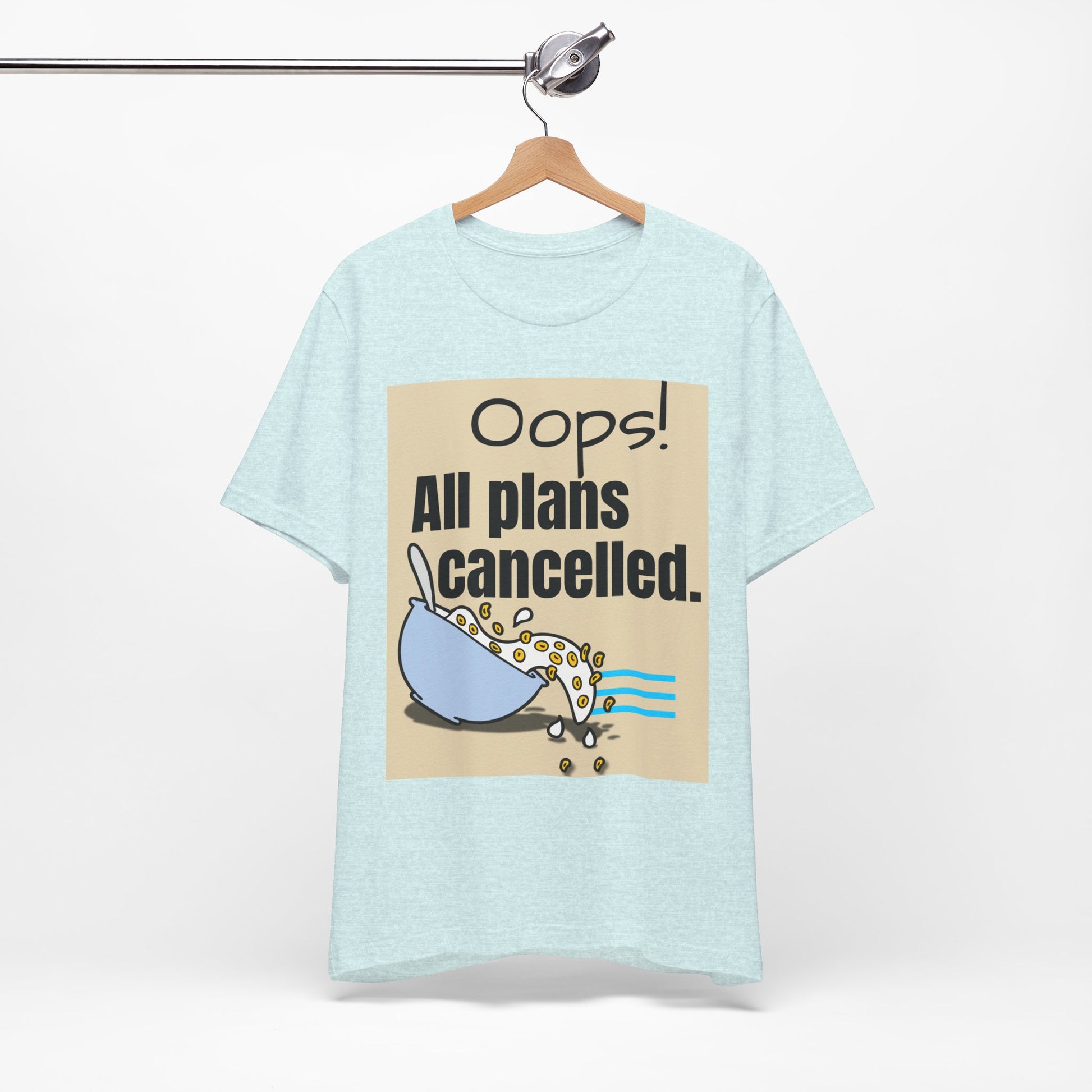Light blue t-shirt with graphic and text 'Oops! All plans cancelled.' on a hanger against a white background
