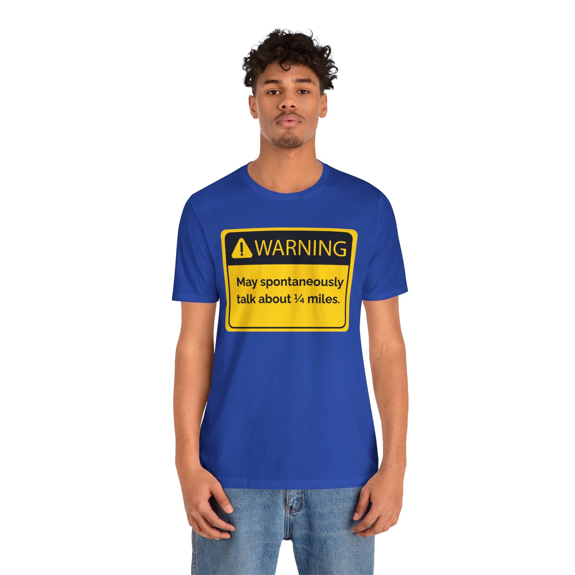 Person wearing a blue t-shirt with a yellow warning sign 'WARNING May spontaneously talk about 1/4 miles' graphic on a white background