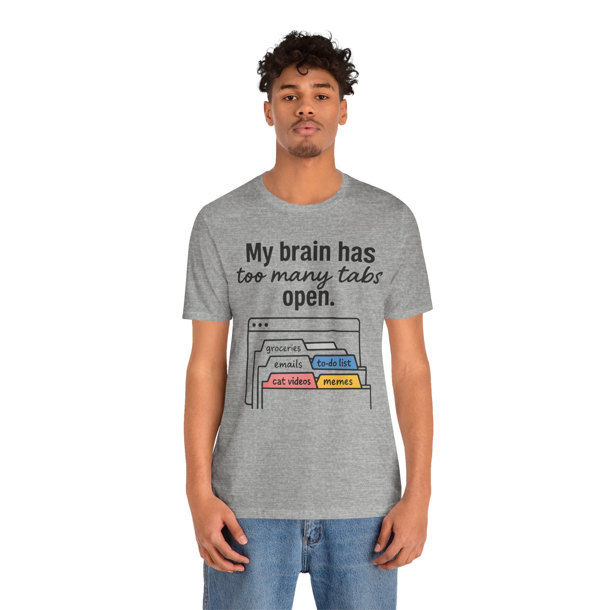 Person wearing a gray t-shirt with text 'My brain has too many tabs open' and graphics on a white background